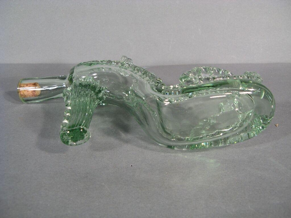Add a touch of whimsy and sophistication to your bar or dining area with this unique vintage glass shoe-shaped decanter from the mid-20th century. This charming piece is sure to be a conversation starter and a delightful addition to any