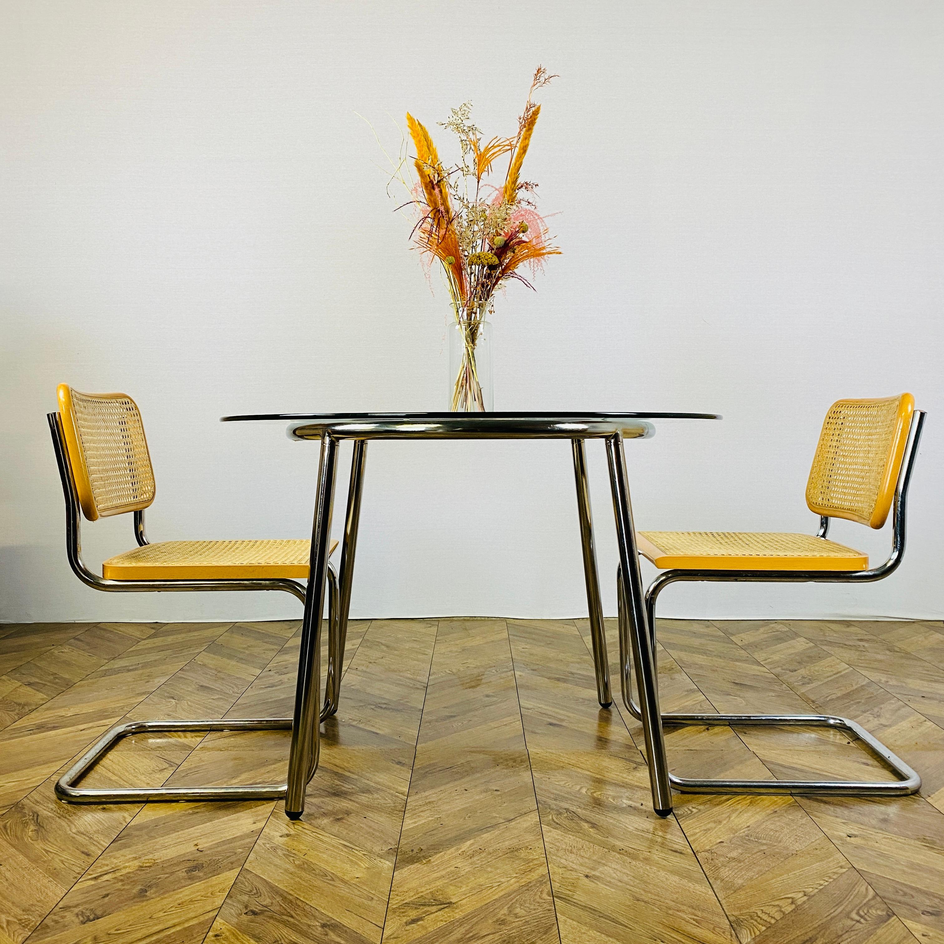 A Vintage, Modernist glass and chrome dining table + set of 2 Marcel Breuer B32 ‘Cesca’ chairs.

The tubular chrome frame and the glass top are in great vintage condition, with no chips and only minor wear, in-keeping with its age and