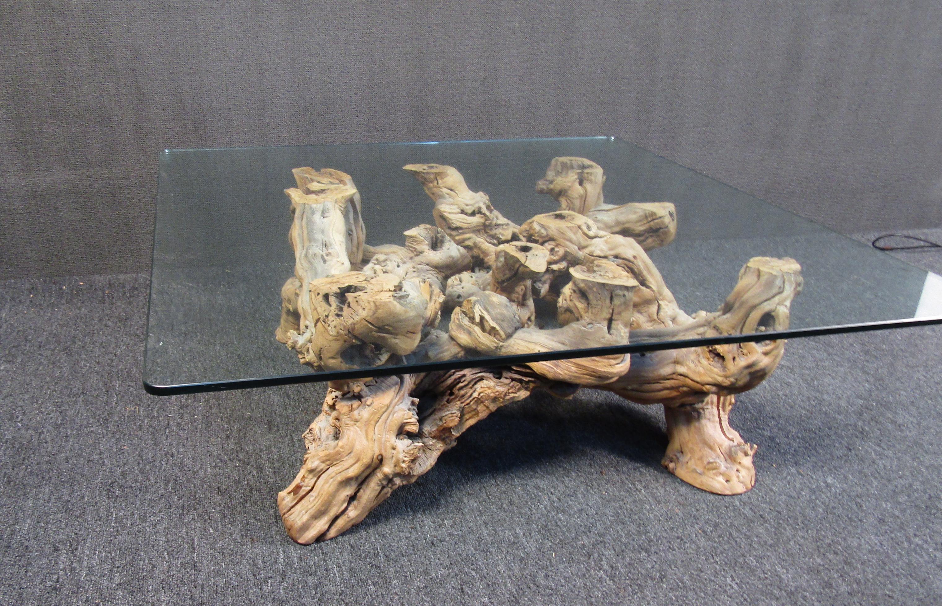 This one of a kind coffee table features a base of intertwined driftwood and a glass top for a unique look. The well-preserved wooden base brings a small piece of nature into any home or space. Please confirm the item location (NY or NJ).