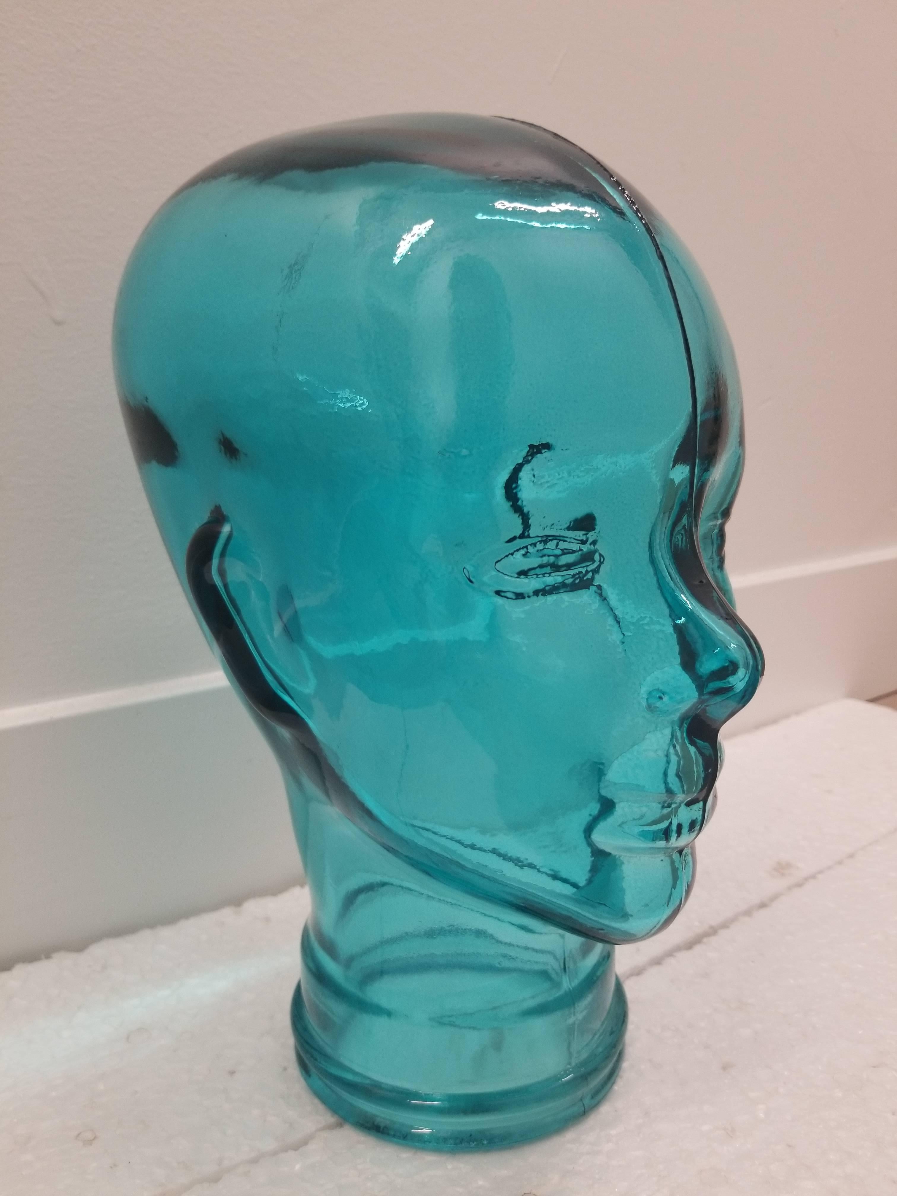 This turquoise colored glass sculptural head is a colorful and playful addition to any designed bookcase or coffee table. The light plays beautifully upon it!