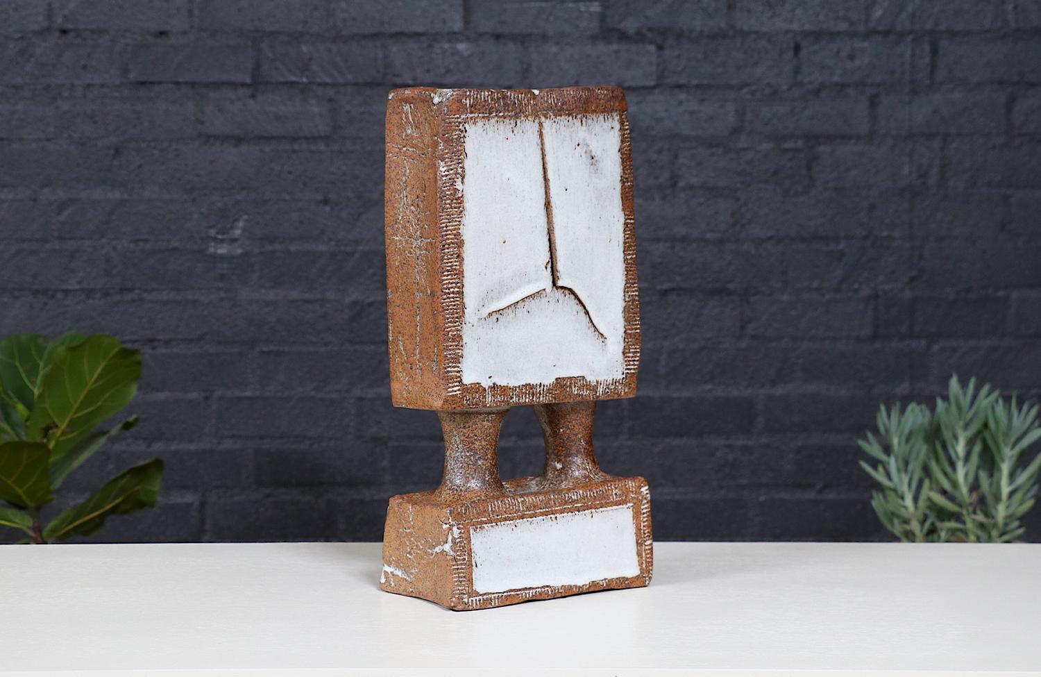 Vero e proprio testamento dell'arte moderna di metà secolo, questa scultura vintage in ceramica smaltata presenta una forma audace e architettonica con sorprendenti ritagli geometrici e uno spazio negativo dinamico. La sua silhouette scultorea gioca