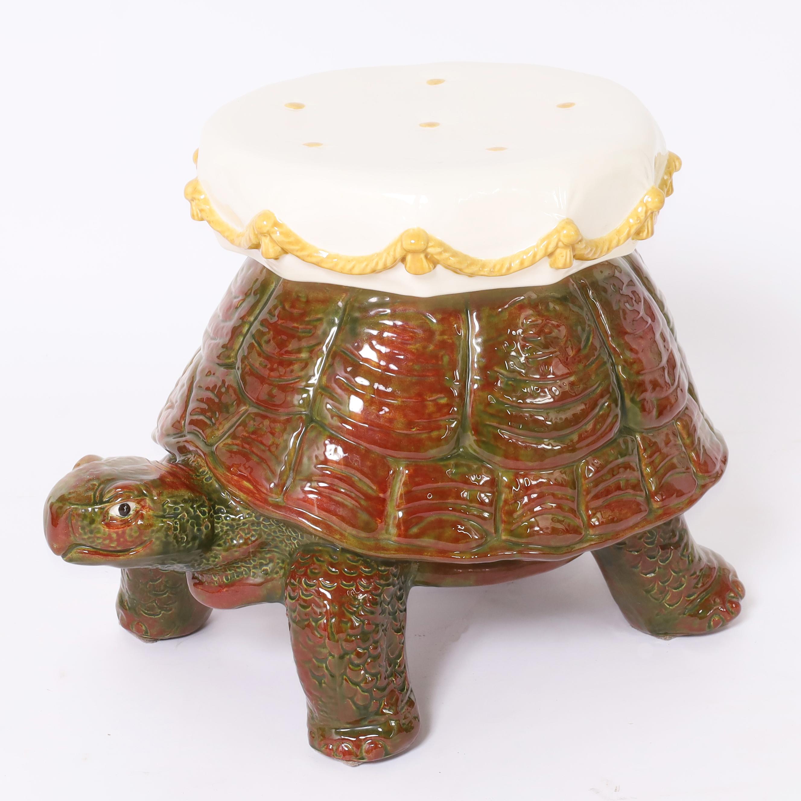 Charming mid century Italian tortoise carrying a button tufted pillow with a rope and tassel motif, crafted in ceramic, hand decorated and glazed.