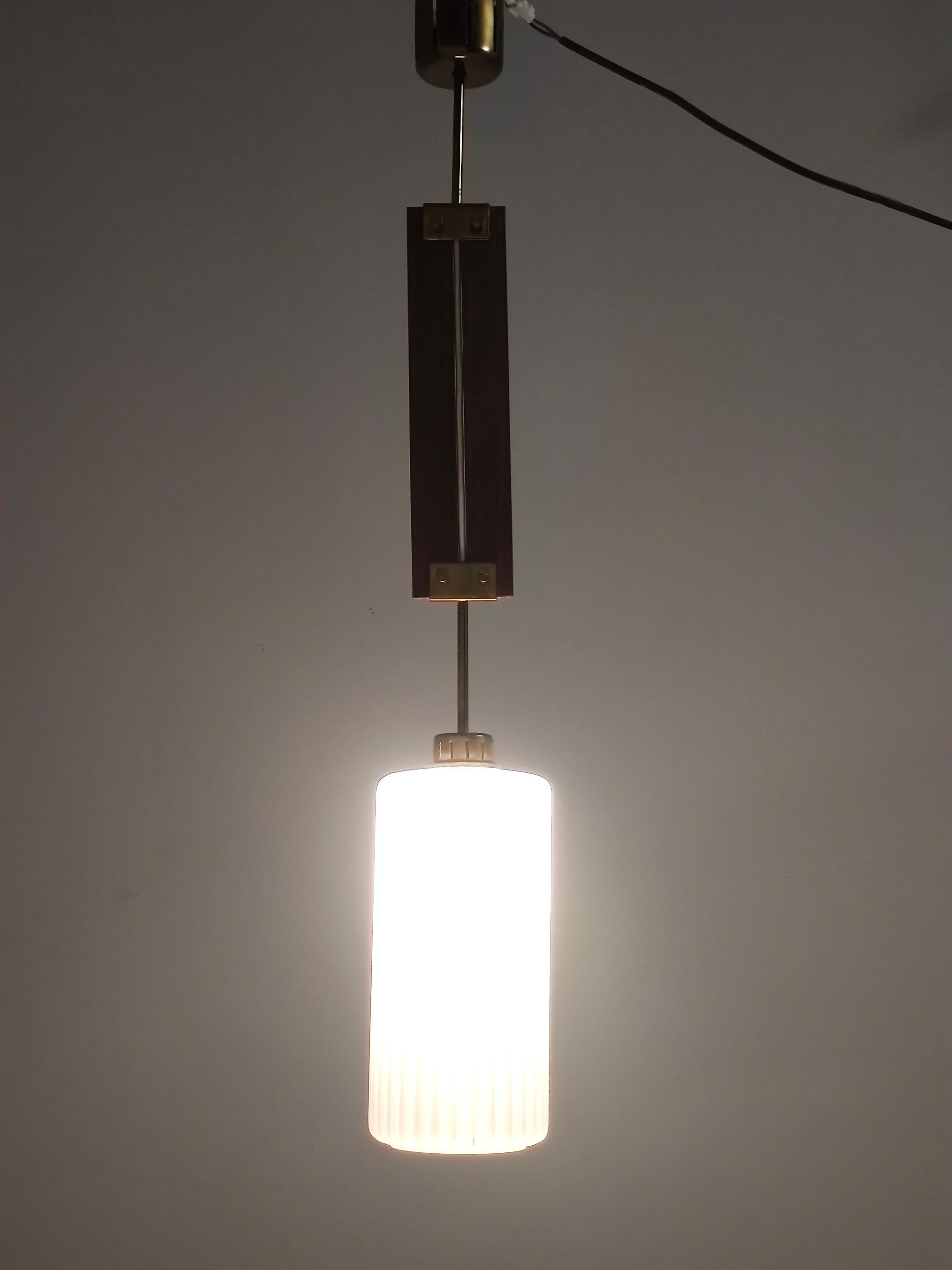 Made in Italy, 1960s.
This pendant is made in glazed opaline glass, teak and brass.
It is a vintage item, therefore it might show slight traces of use, but it can be considered as in excellent original condition and ready to give a beautiful