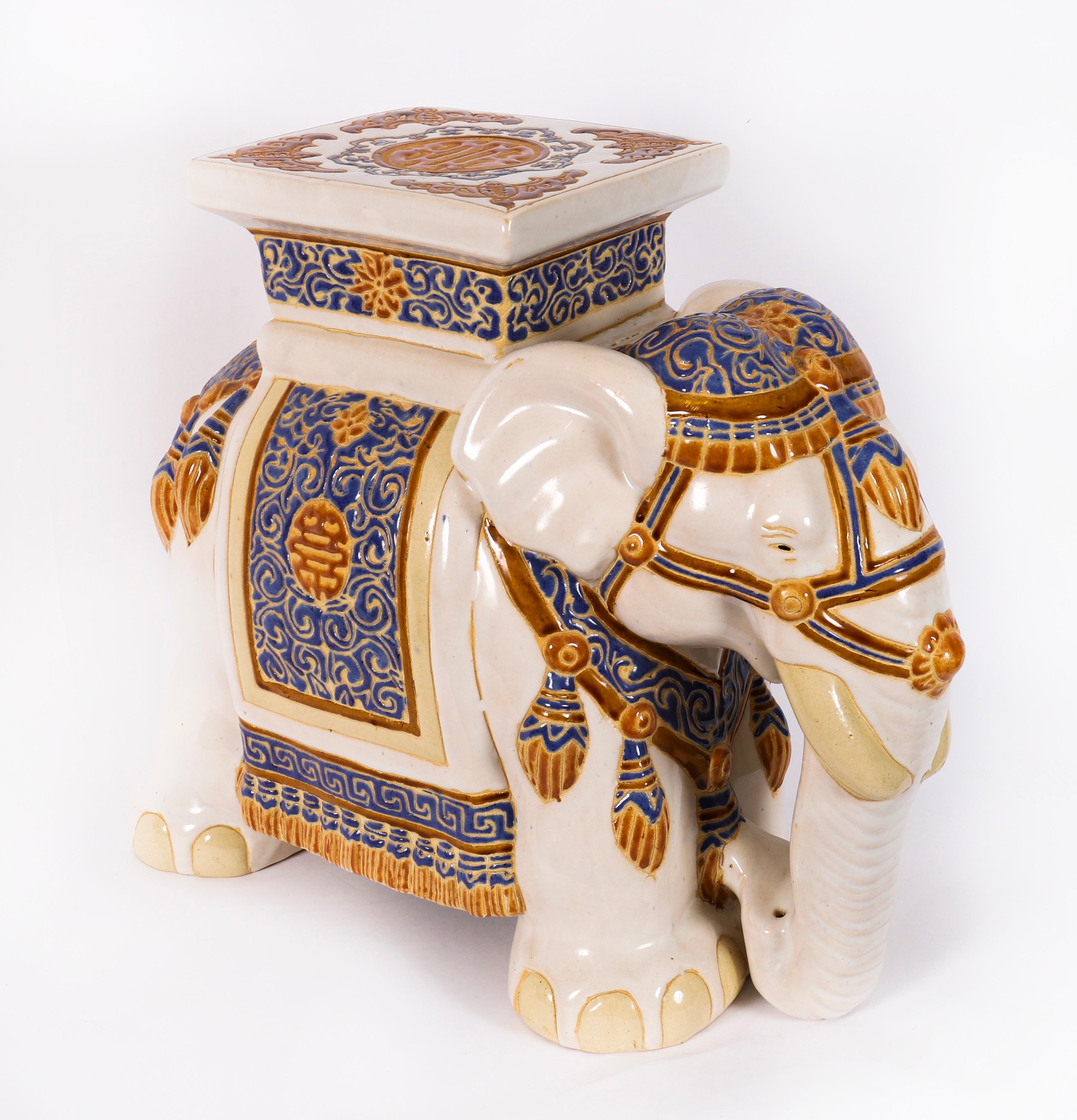 Ein wunderschöner glasierter Keramik-Gartensitz oder Topfständer in Form eines Maharaja-Elefanten in zeremoniellem Kleid, Mitte des 20.

Der stilisierte weiße, polychrome Elefant ist mit einem blau-goldenen traditionellen Zeremonialkostüm