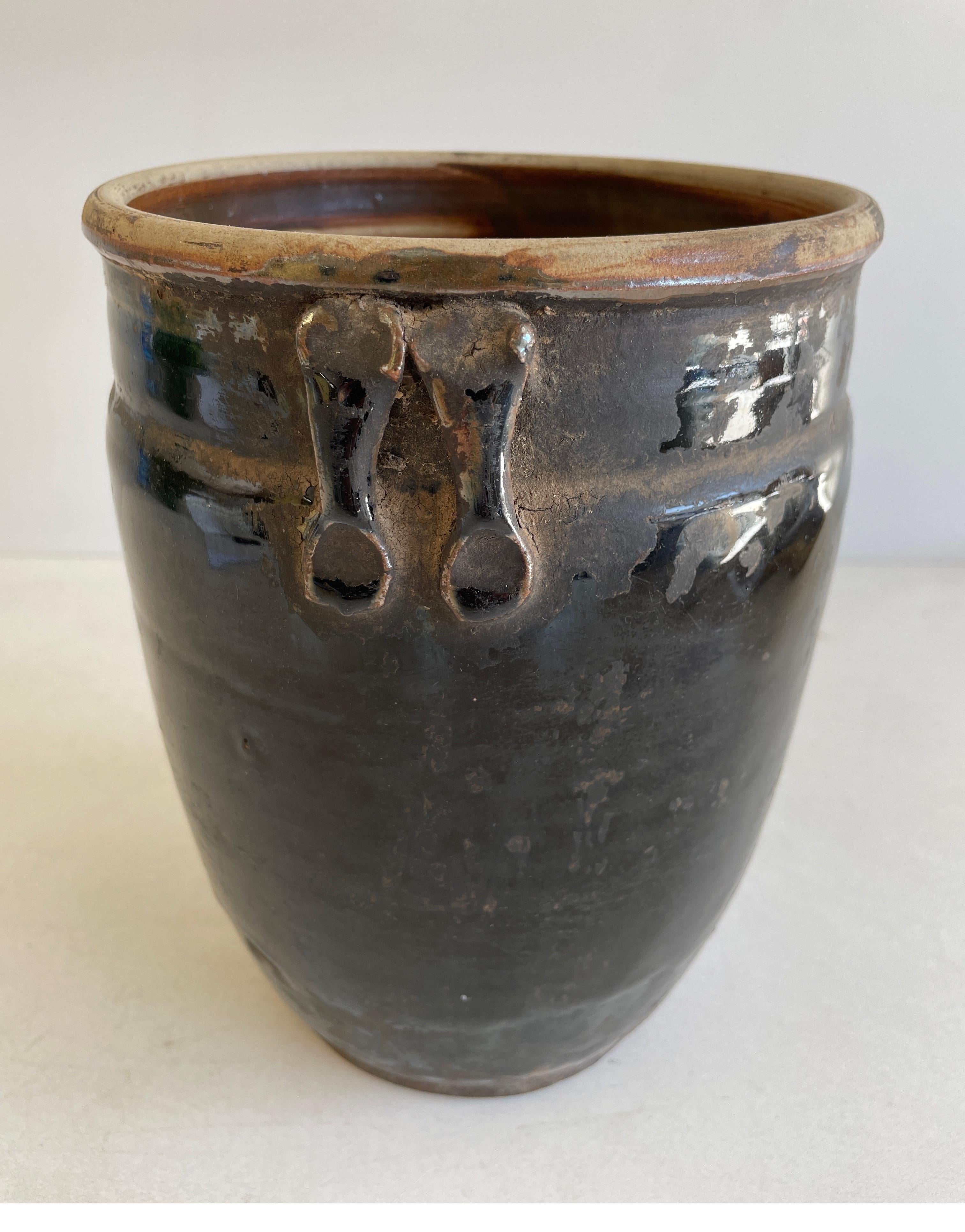 Beautifully glazed and rich in character, this vintage glazed oil pot adds just the right amount of texture + warmth where you need it. Stunning black glazed finish with warm terra-cotta accents.

Sizing 9” H x 6.5” D x 6.5” W.