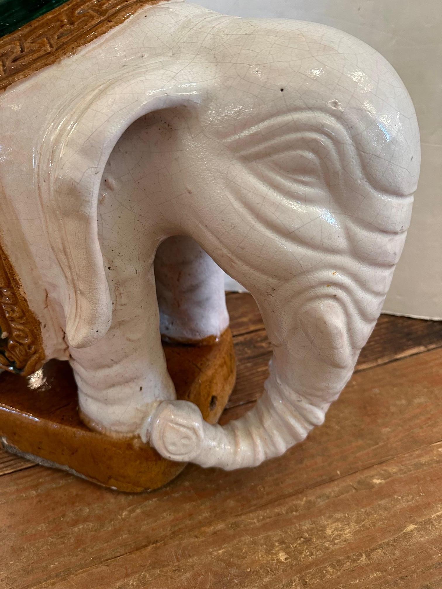 Vintage painted stoneware end table Chinese garden seat in the shape of an elephant having octagonal top surface. Nice earth colors including gold and green adornments on a creamy white elephant. Some losses here and there that don't effect overall