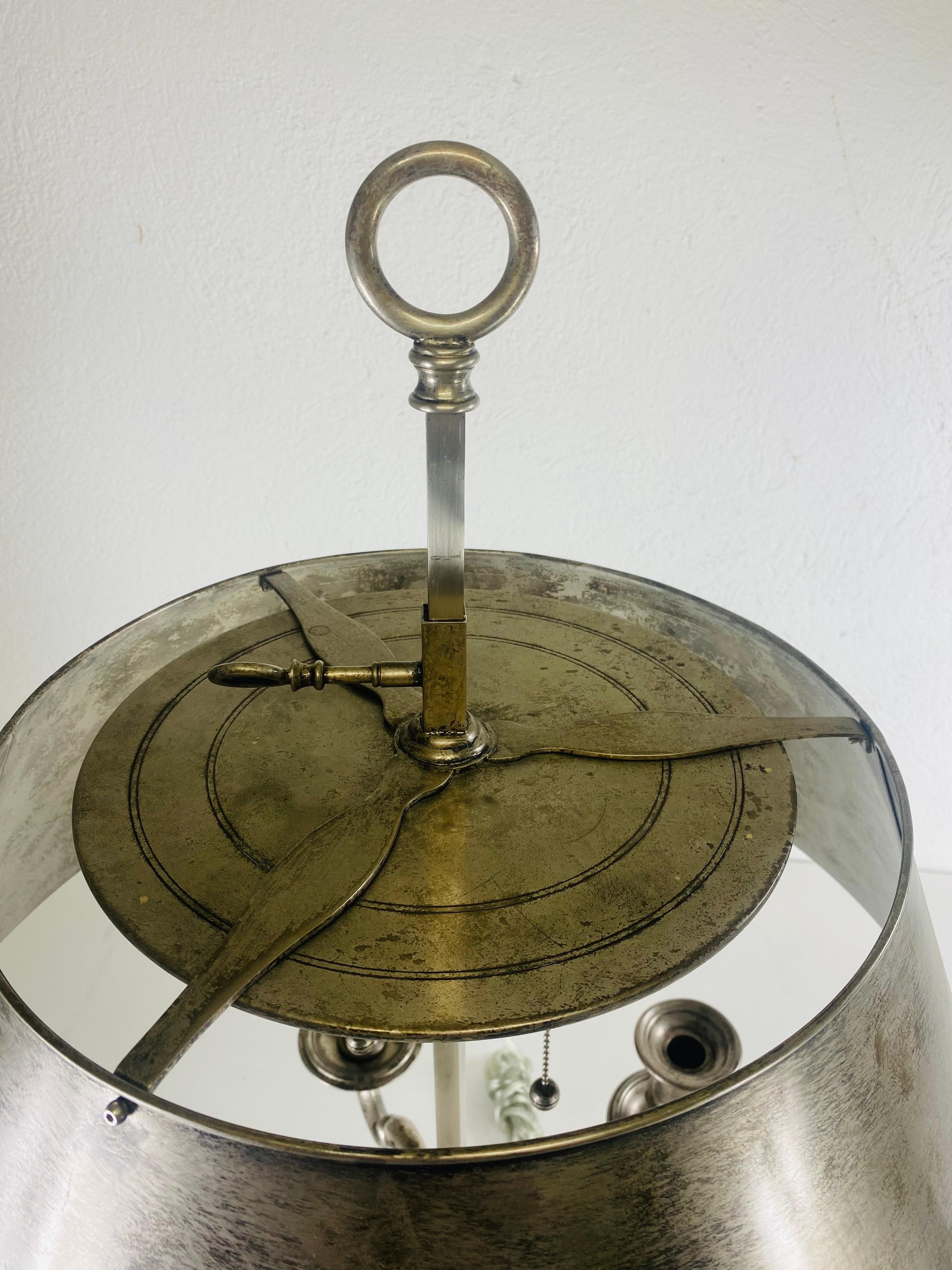 This is a vintage large global views  French inspired Bouilotte table lamp. This large Bouilotte table lamp is made of highly polished steel with a distressed antiqued finish to the metal. The lamps shade is adjustable up and down and has a S