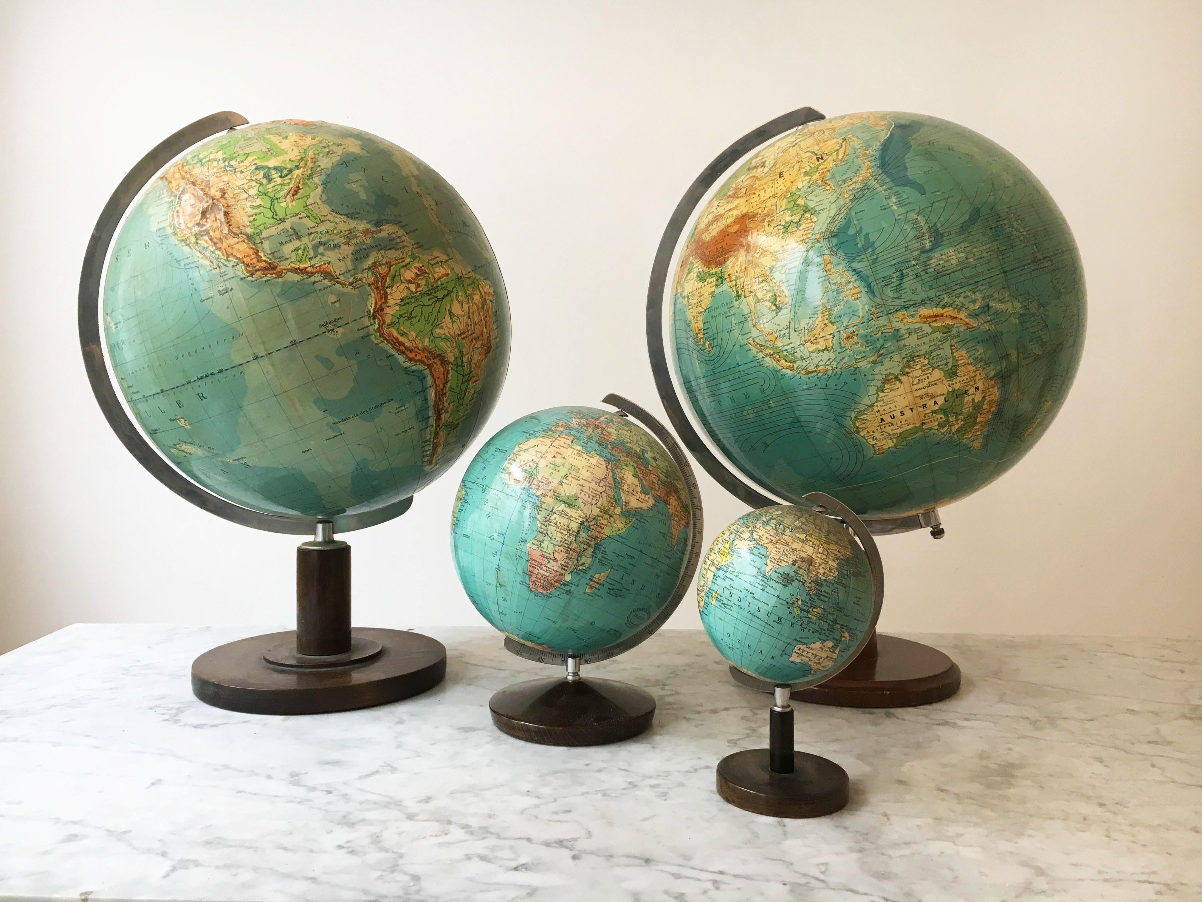 Vintage Globes collection of four, collected over many years of traveling in Europe, with an eye for beautifully curated objects. Paul Oestergaard globe manufactured by Columbus Verlag in Germany, Stuttgart/Berlin. In variations of size, from small