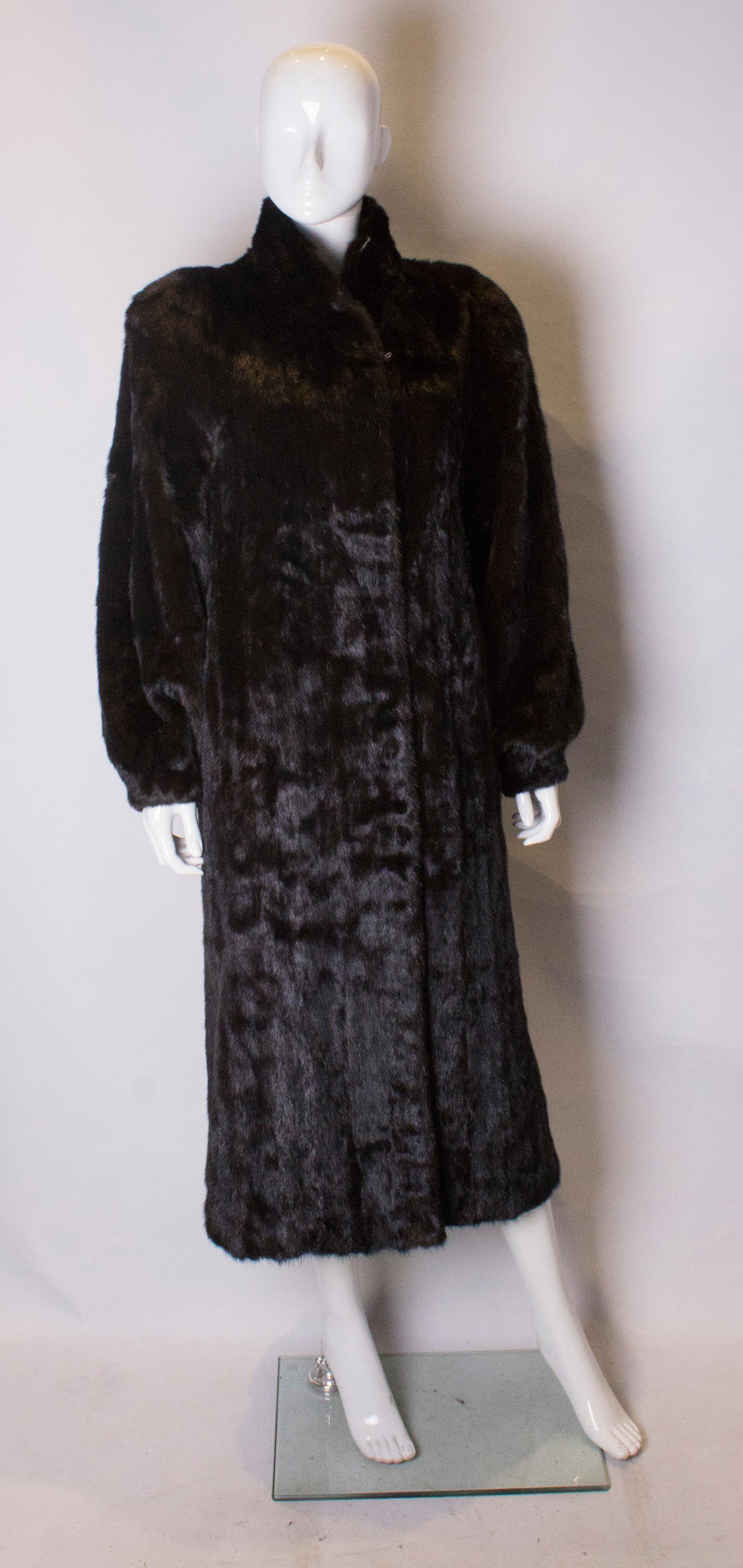 A chic and shinny full length mink coat.  The coat is fully lined, and easy to wear, with tapering sleaves.