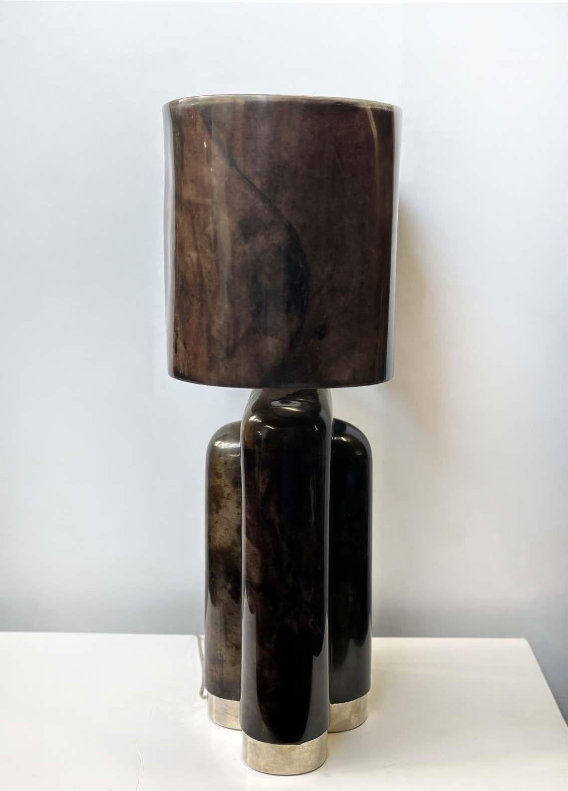 Vintage goatskin and parchment table lamp in dark shades of aubergine and brown. To enhance its durability and beautiful details, the lamp is finished with a high-gloss polyester resin, which not only protects the surface but also gives it a