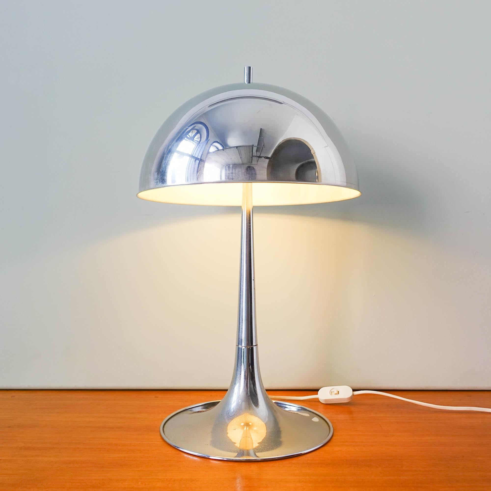 This table lamp was designed bu Goffredo Reggiani for Reggiani, in Italy, during the 1960's. It is a chromed metal lamp with a mushroom shade and a trumpet base. With the original tag from the producer. In original and good condition.