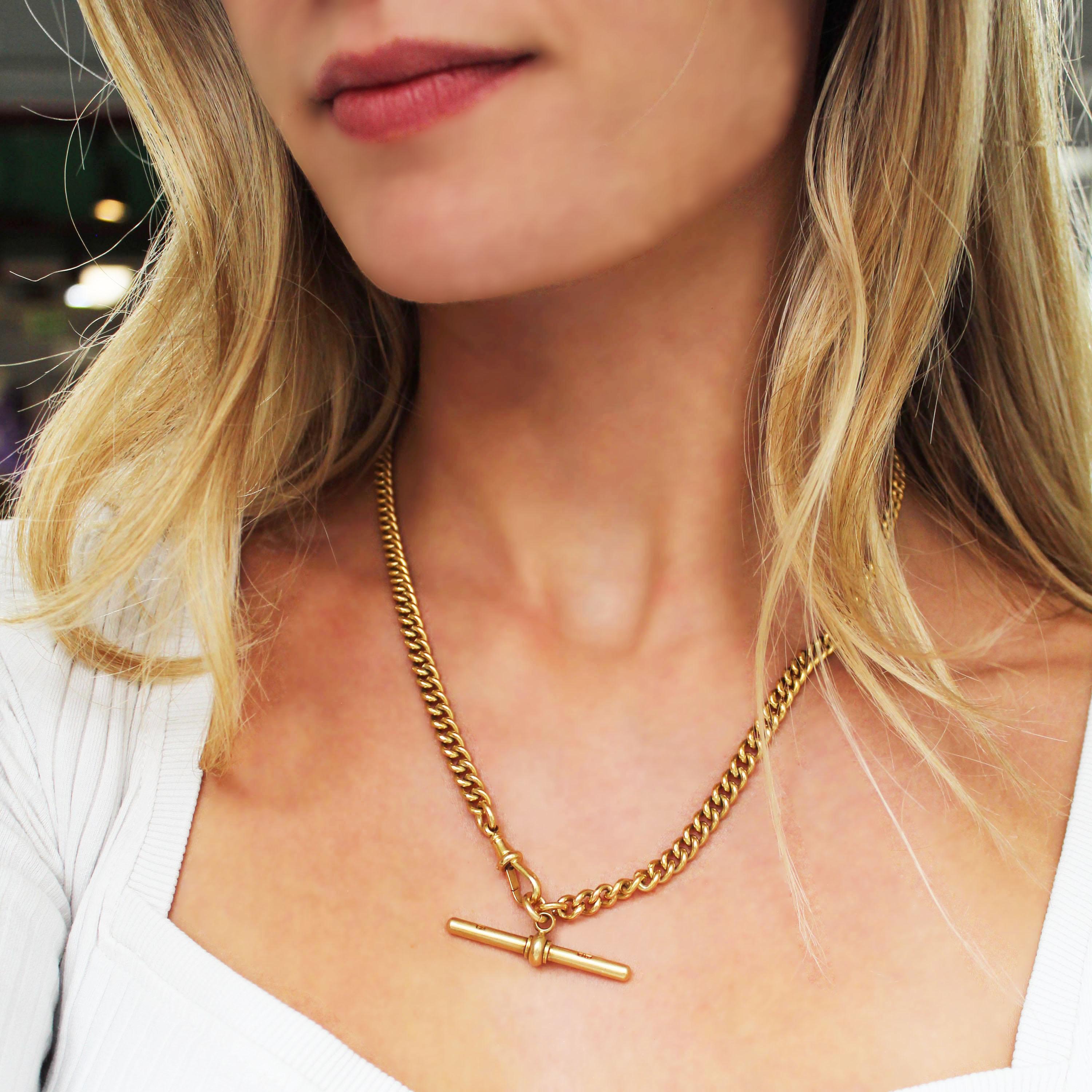 Eine goldene Vintage-Albert-Kette mit schweren, massiven Kettengliedern, einem T-Steg und Karabinerverschluss, montiert in 18-karätigem Gold, mit 18-karätigem oder 750er Punzierungen auf jedem Glied, mit Sponsorenzeichen auf dem T-Steg und dem