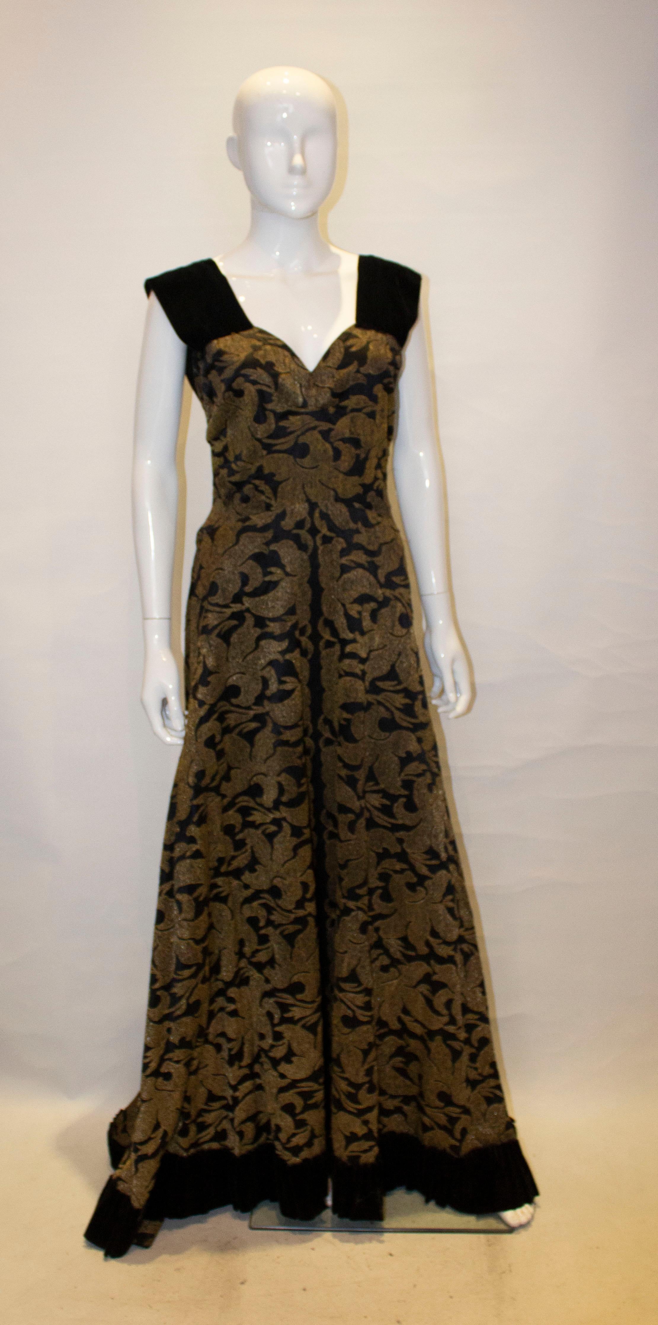 Ein aufsehenerregendes Vintage-Abendkleid aus schwerem schwarz-goldenem Stoff mit schwarzem Samtbesatz. Das Kleid hat Träger und Saum aus schwarzem Samt und einen seitlichen Reißverschluss.