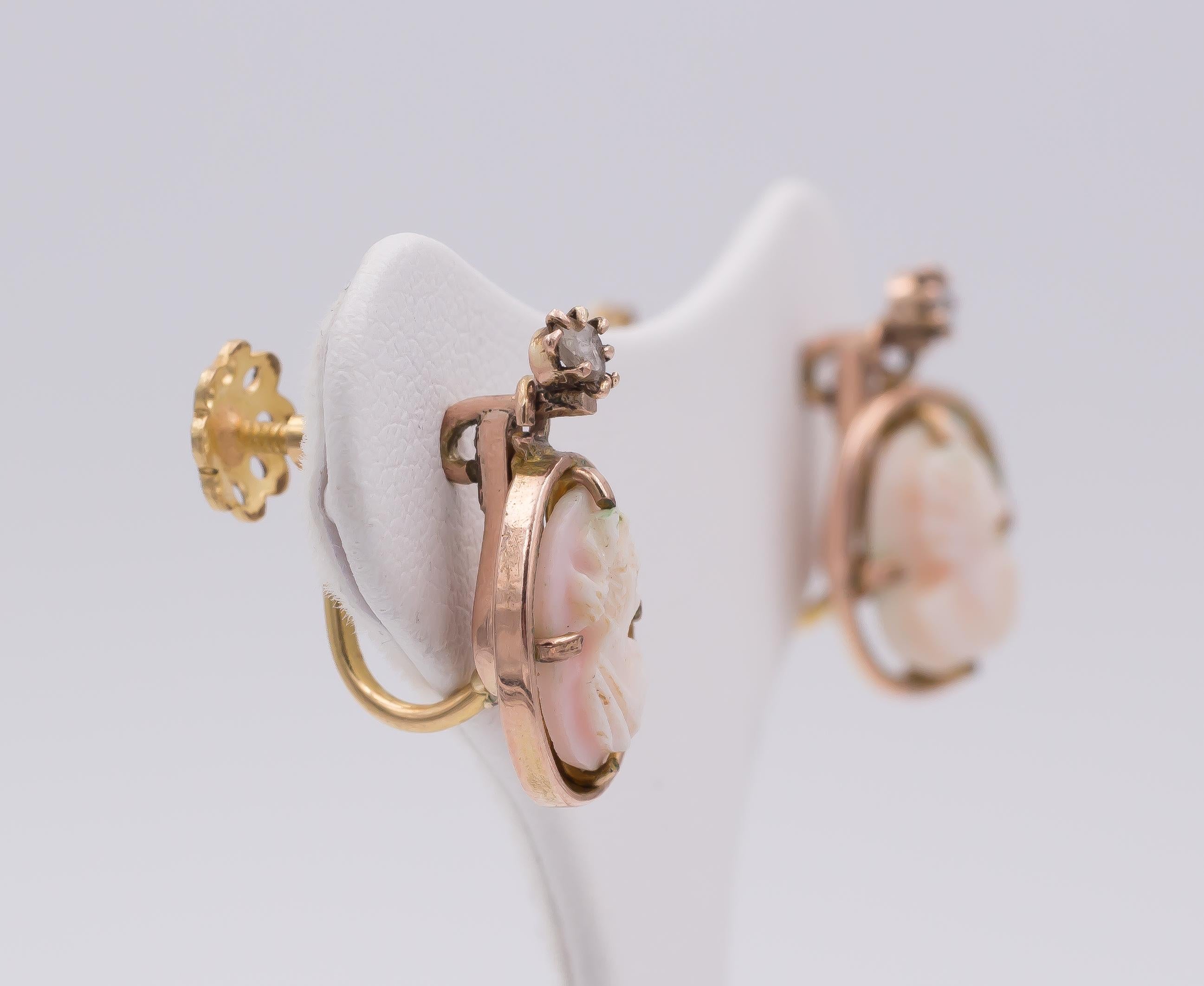 This lovely and elegant pair of earrings is crafted in gold throughout and dates from the 1950s: each earring is set with a beautiful rose cammeo, depicting the profile of a noble woman and each one is decorated with a rose cut diamond.