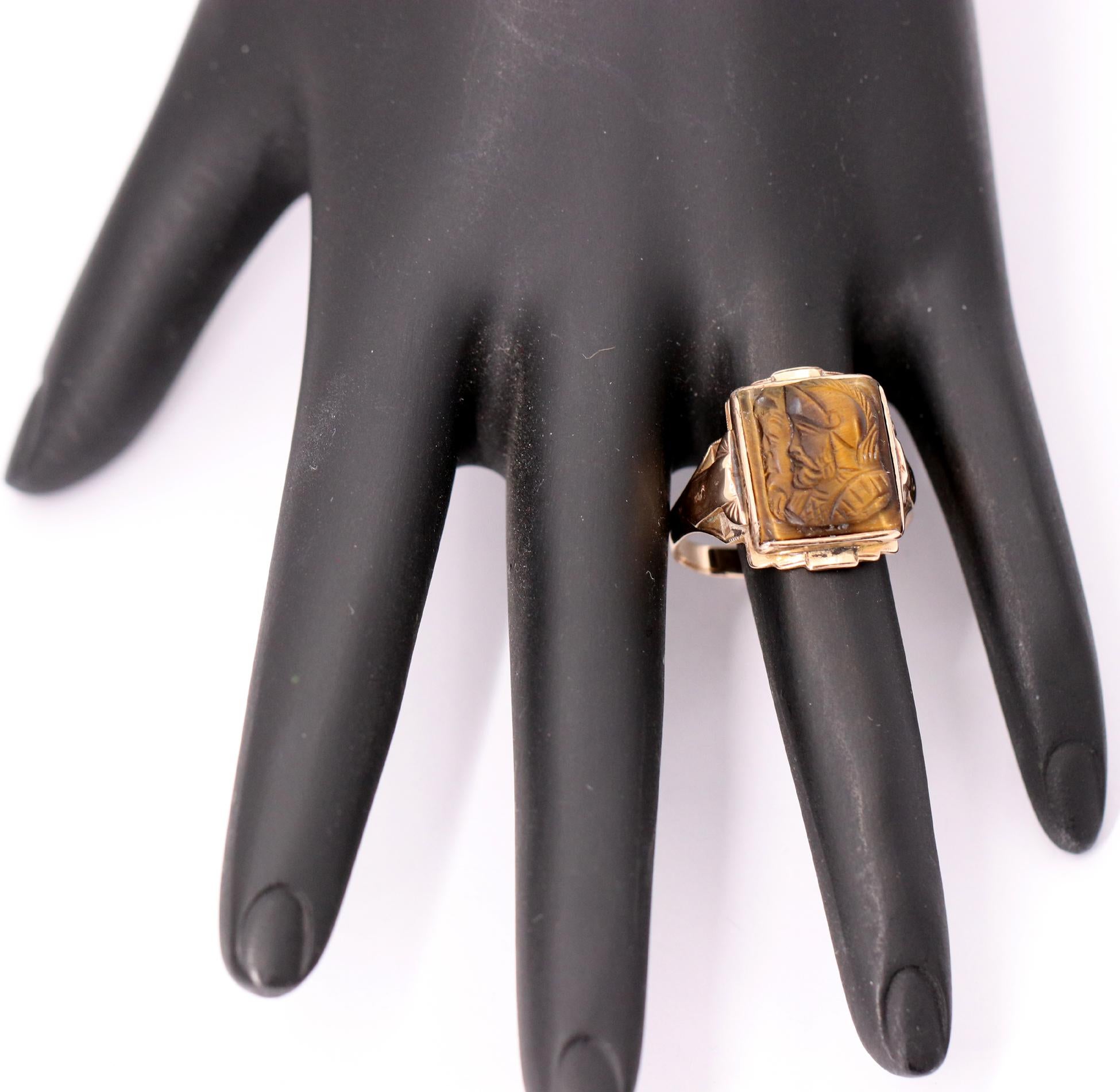 A vintage 10K yellow gold ring, centered around a carbon tiger's eye conquistador, resembling the literary figure 