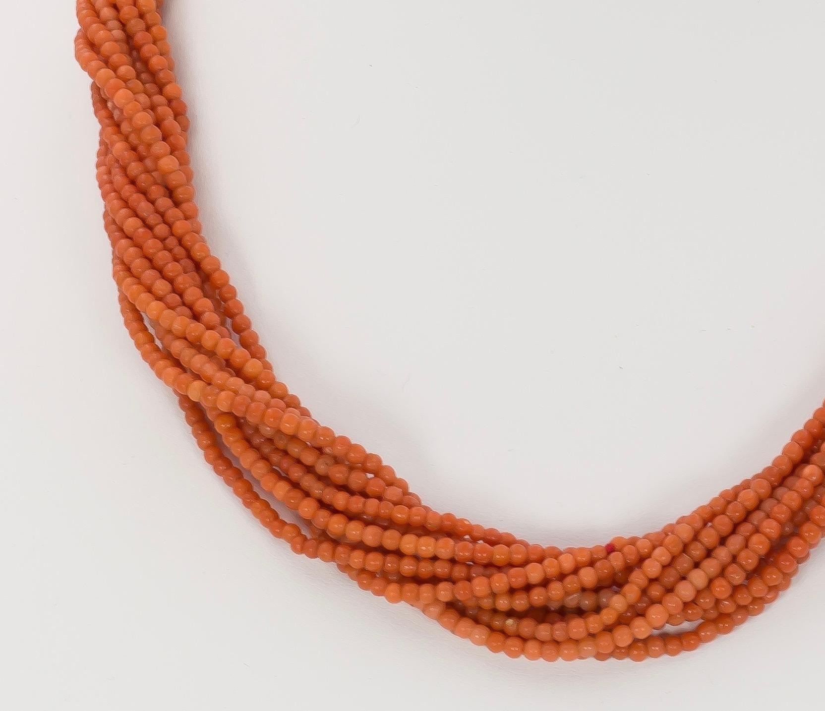 A very elegant vintage coral torchon necklace, dating from the 1970s, set with multi coral beaded strands; the small beads, of a beautiful orange color, create a lovely and soft effect. The clasp is crafted in gold throughout.

MATERIALS
Gold and