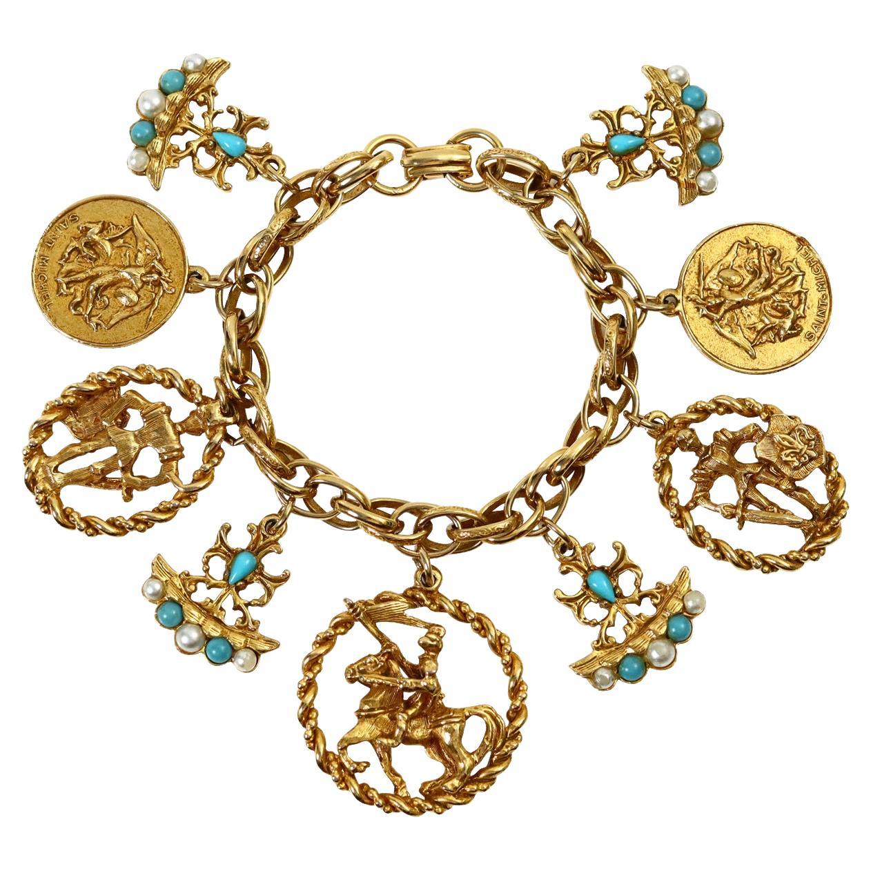 Vintage Gold and Faux Turquoise Charm Bracelet Circa 1980's.  This charm bracelet features charms that have various coat of arms motifs. The pop comes from three arms that have faux turquoise and faux pearls which really pop against the gold.  You