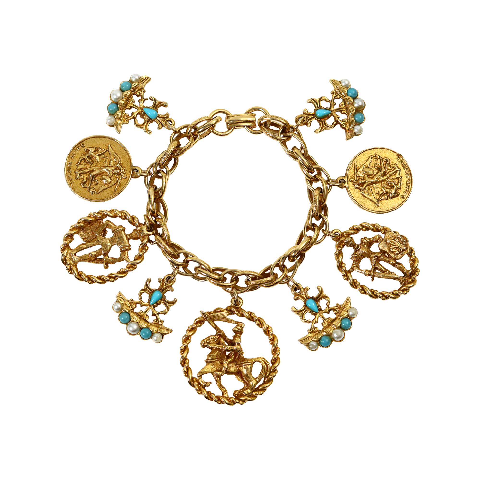 Bracciale con charme d'oro e finto turchese d'epoca, circa anni '80. Questo braccialetto di ciondoli presenta charme con vari motivi di stemmi. L'effetto pop è dato da tre bracci che presentano finti turchesi e finte perle, che risaltano davvero
