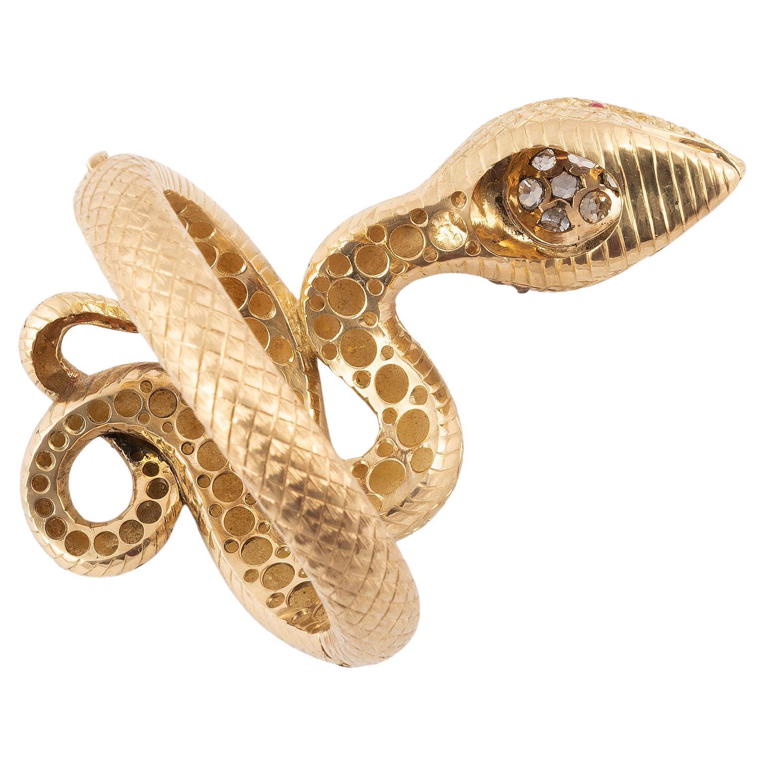 Bracciale bangle grande disegnato come un grande serpente con diamanti taglio vecchio di circa 3,5 carati sulla testa e occhi di rubino.
Lunghezza: 12 cm
Diametro 6.5 cm.  
Peso: 153 gr.


