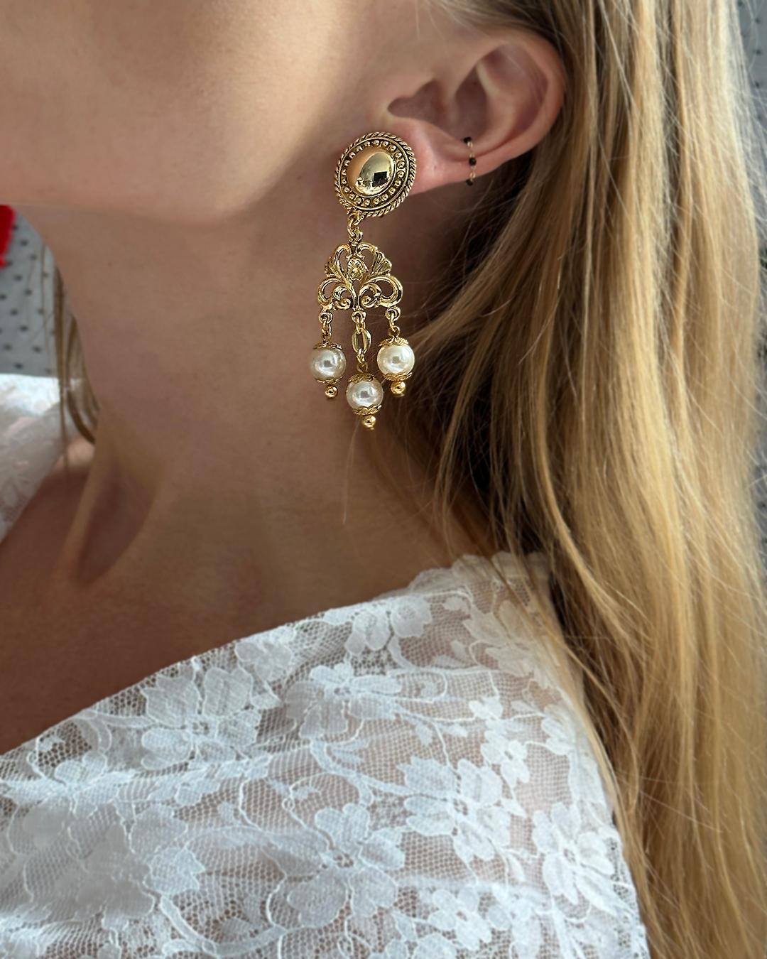 VERY BREEZY presents: These vintage pearl earrings are so dramatic and feminine at once; made in Europe, they immediately convey that romantic sensibility. They feature a baroque gilt motif, with three pearl drops. The classic gold and pearl