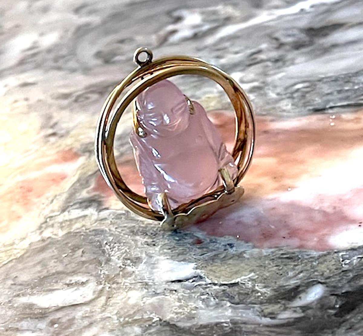 Fabulous 14k yellow gold oversized buddha charm perfect for hanging as a medallion from a long chain or adding to a charm bracelet. The carved pink quartz buddha sits within three criss crossing thick thick gold wires - orb like - on a decorative