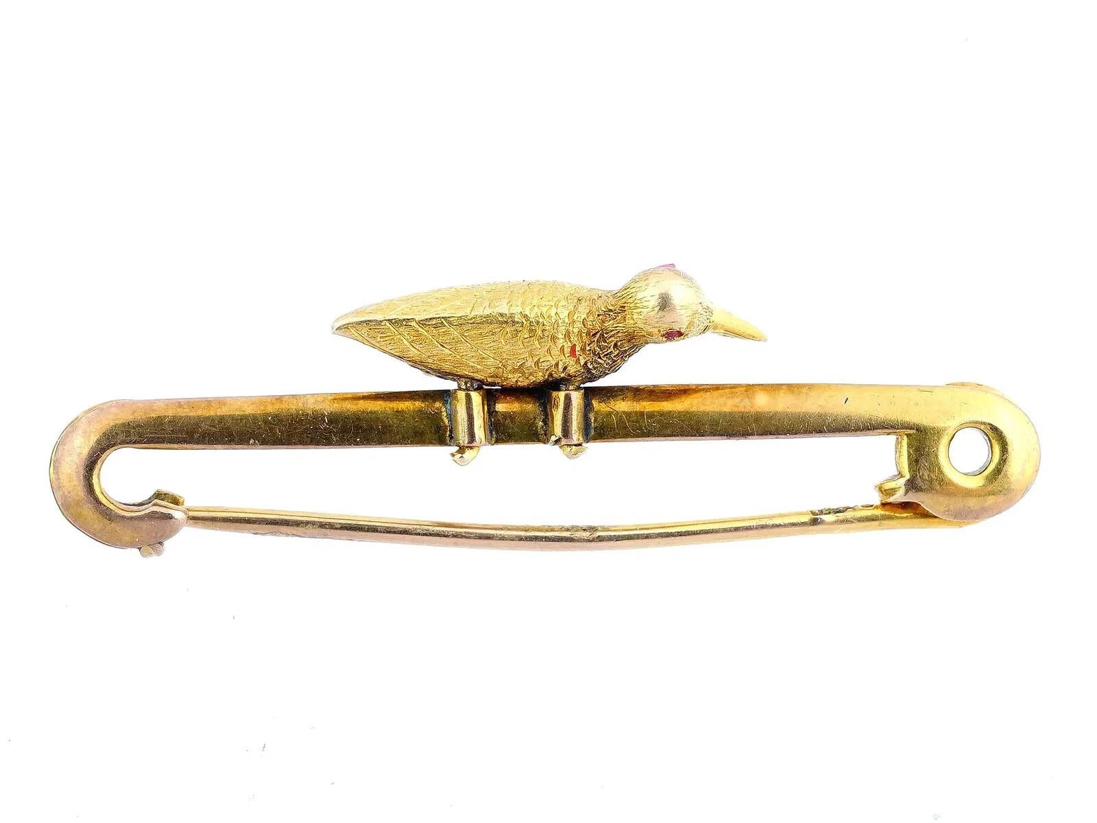 Gelbgoldene Brosche im Vintage-Stil mit einem geschnitzten Vogel. Die Augen des Vogels sind mit geschliffenen Rubinen besetzt. Spuren einer Punzierung auf der Brosche. Gesamtgewicht: 4,48 Gramm. Luxus-Schmuck für Frauen,