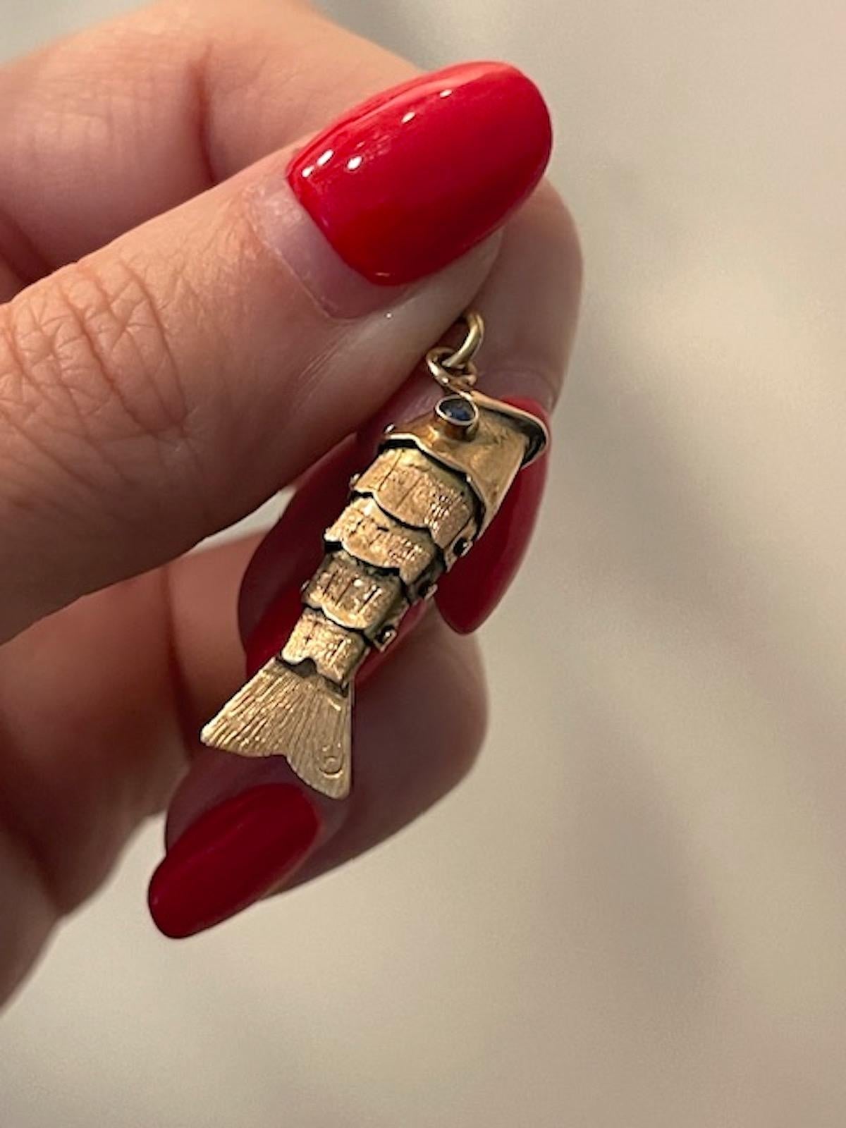 Vintage 14k gold articulated fish charm with electric blue sapphire eyes. Articulated fish charms are highly coveted and this one is highly unusual with an open mouth and fabulous eyes.
1