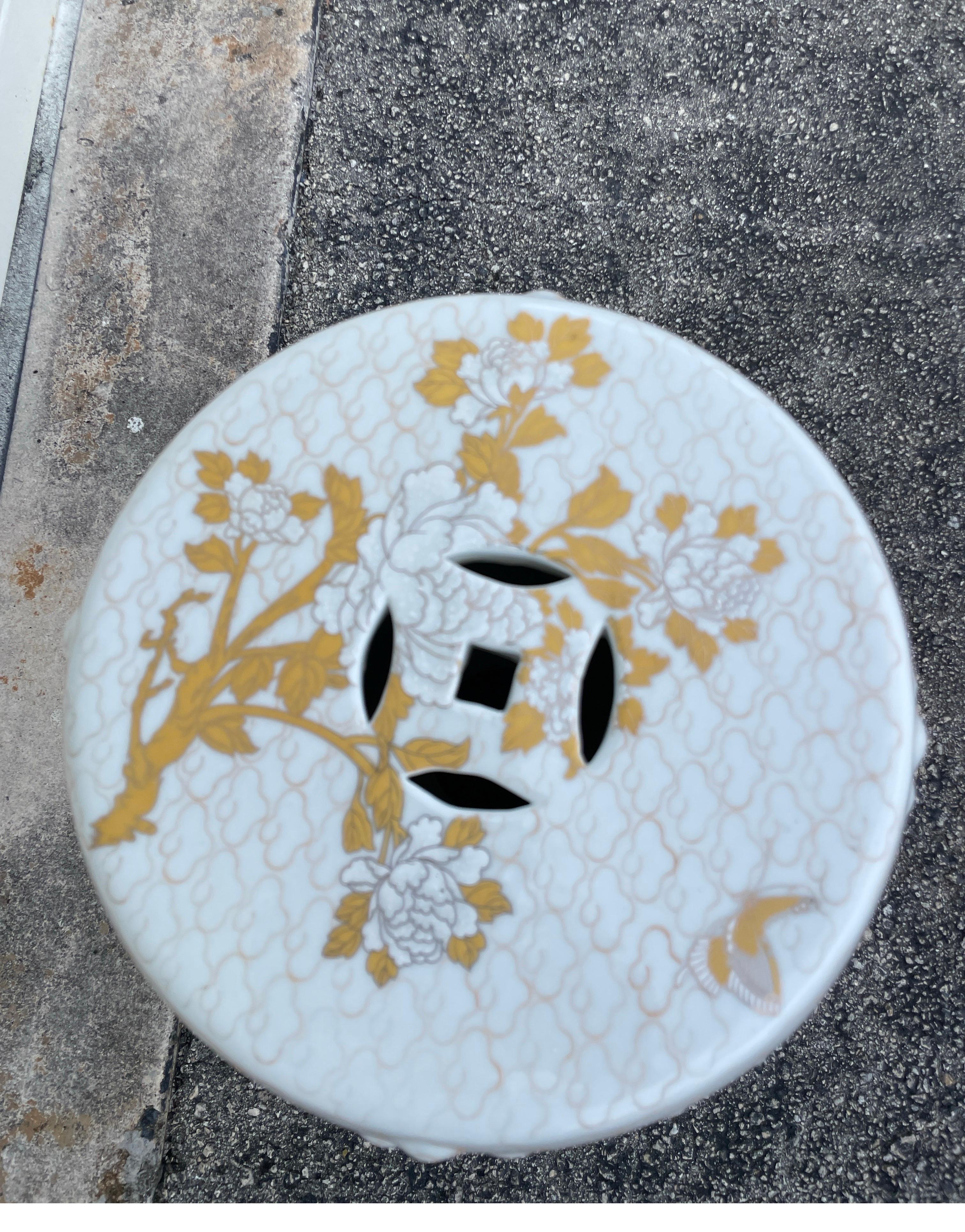 Vintage white and gold chinoiserie style garden seat. The design consists of large white blooms with gilt vines and leaves. Diameter of top is 12