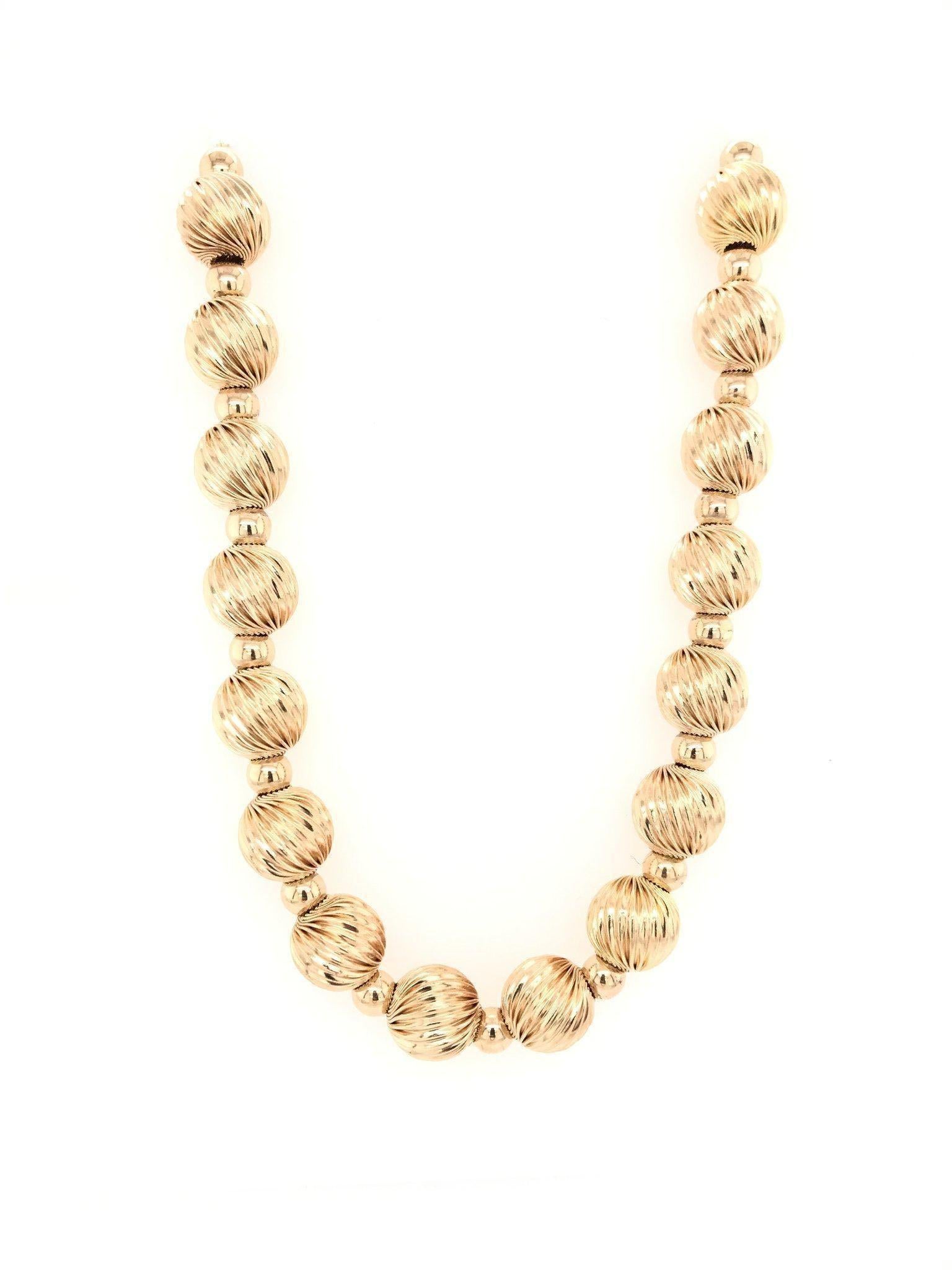 This vintage necklace was crafted sometime during or after the Mid Century design period ( 1950-1980 ). This necklace features 40 10mm 14k yellow gold balls in a stylized twist design as well as 41 small 14k yellow gold bead dividers. The beads are