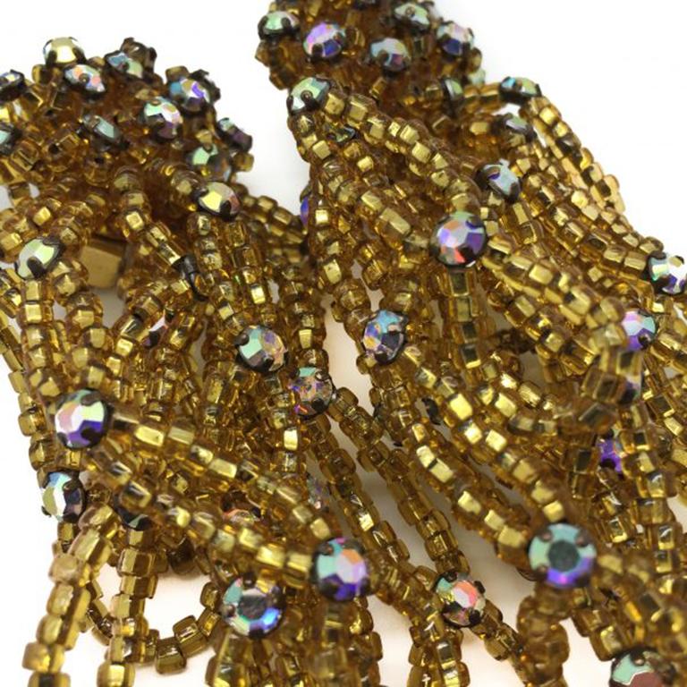 A hugely fun pair of 1950s-60s statement Gold Bead Earrings. Featuring 10 strands of claw set crystals sitting in rows of glass microbeads, all descending from a circular top stacked with claw set aurora borealis crystals atop individual mounds of