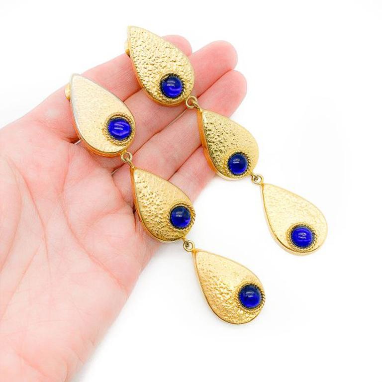 Vintage Gold Teardrop Earrings. Featuring hammered gold teardrops set with cabochon blue glass stones. Created in gold plated metal. In very good vintage condition, clip on, 10 cms. Please note the reverse of the earrings shows a difference in how