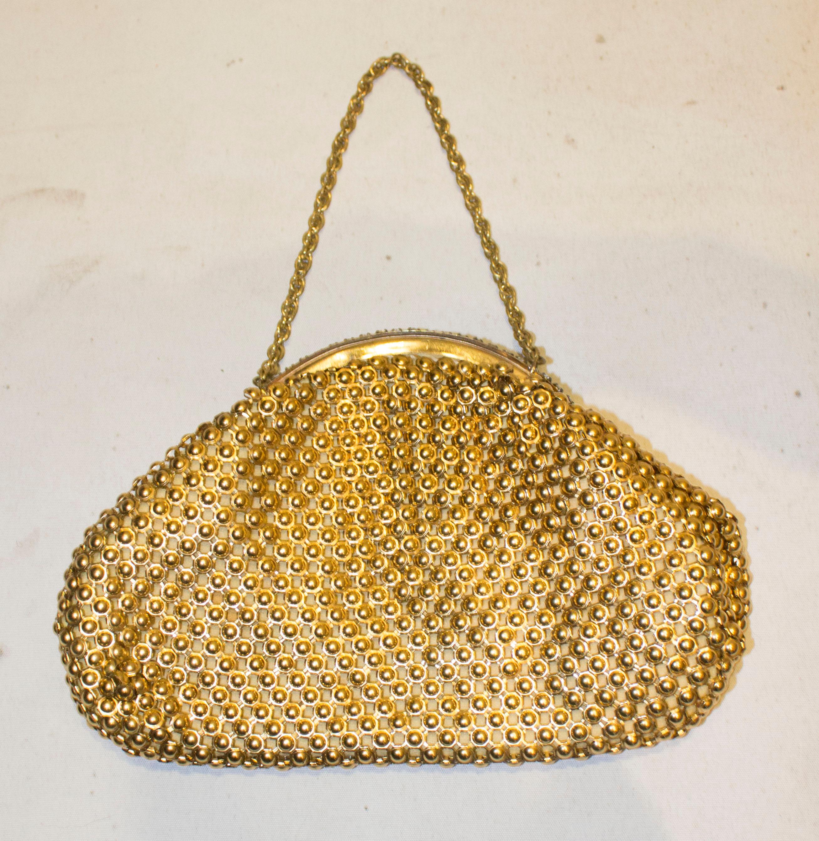 A great bag for evening in  an interesting gold chain metal fabric with diamante decorated frame and clasp. The bag is lined in satin with one pouch pocket and has a 12'' chain handle.
Measurements: width 8'', height 5 1/2''