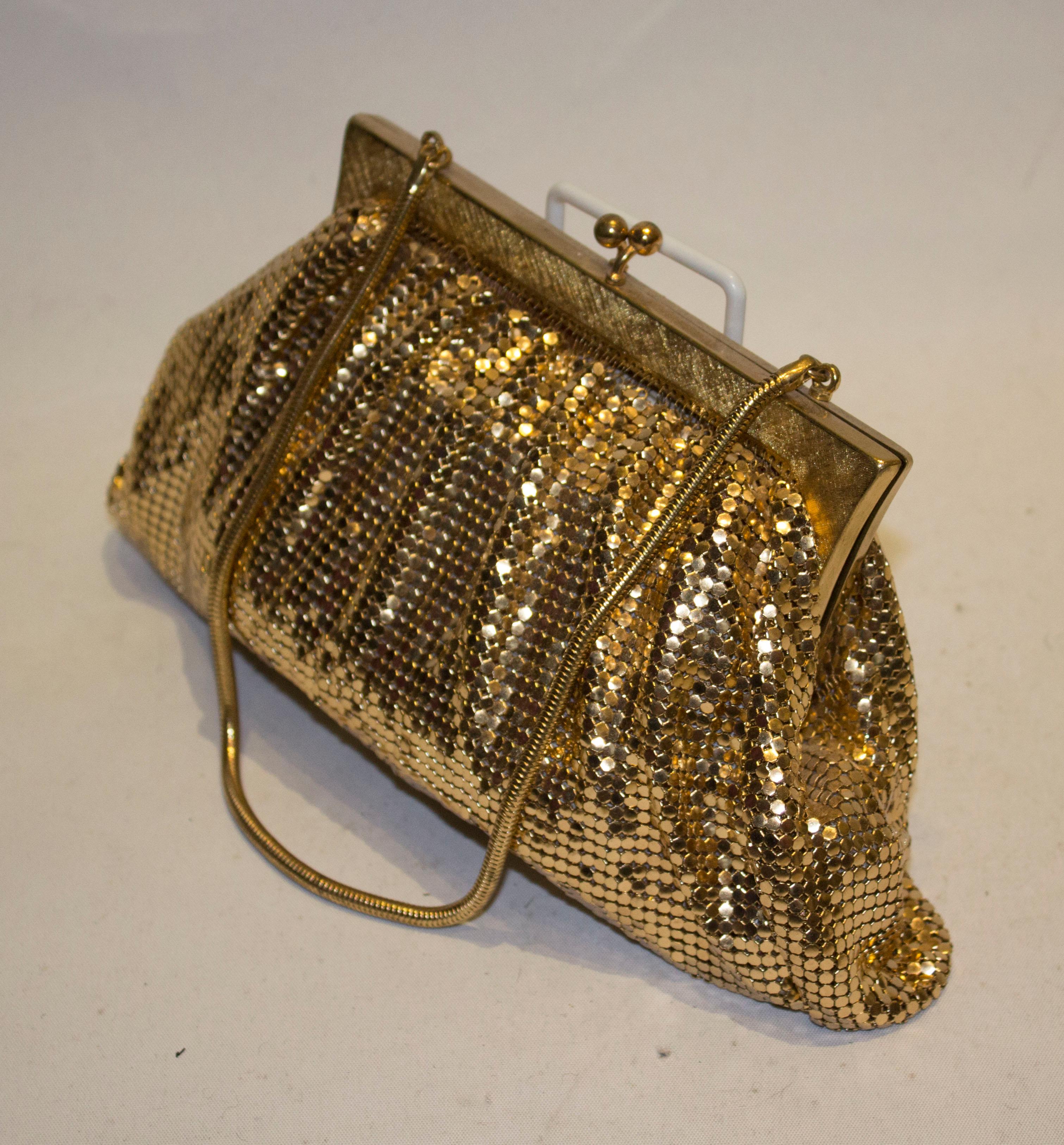 A interesting vintage evening bag in gold chaing mail. Rather unusually there is  gathering on the frame which produces an elegant shape.  The bag has an attractive frame, internal pouch pocket and snake chain handle. Measurements: width 9 1/2'',