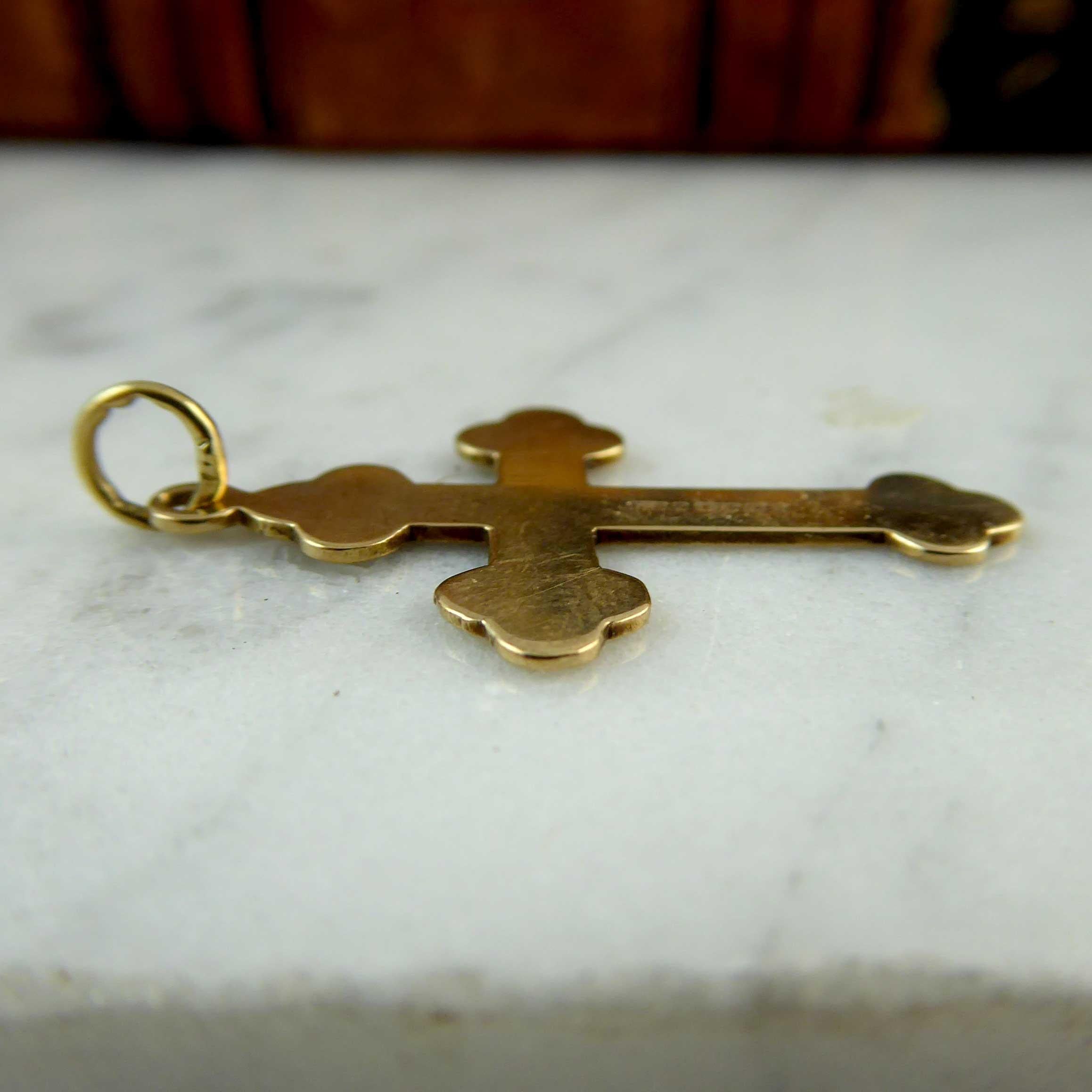A very pretty and dainty gold cross hallmarked at the Birmingham Assay Office in 1990.  The cross has plain polished, tri-lobe decorations at the four points with, at the intersection a plain polished, stylised star enclosed by scroll work