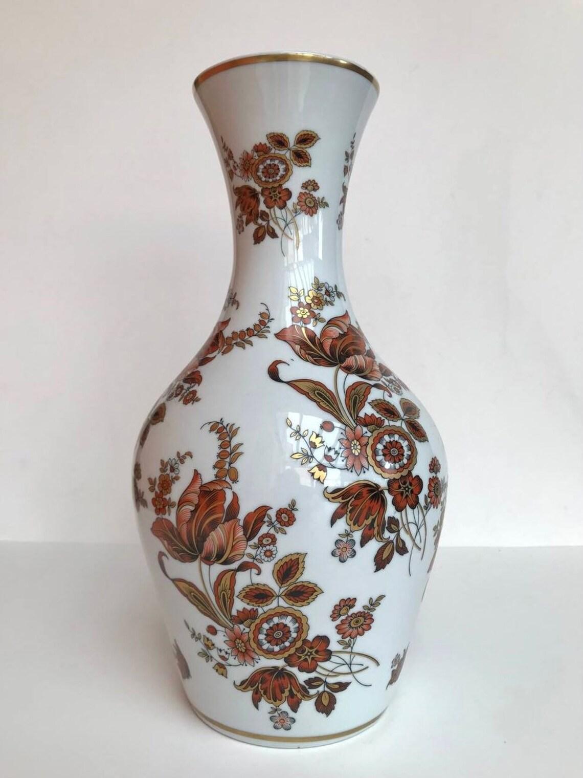 Vintage Porzellan Vase mit Blumenmuster.

Ouragan - Ulysse Paris.

Blumendekor aus 24-karätigem Gold, mit Stempel und Unterschrift auf der Vase.

Jahrgang, 1980er Jahre

In ausgezeichnetem Zustand, keine Chips, Risse oder