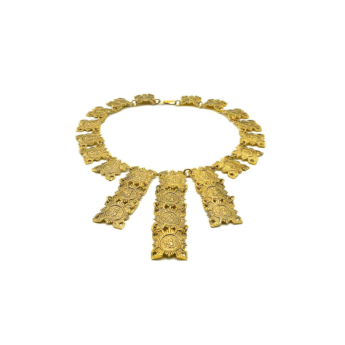 A stunning Vintage gold Egyptian bib from the 1960s; most likely a piece of Egyptian revival jewellery inspired by Elizabeth Taylor's iconic Cleopatra. Crafted in gold plated metal. Featuring medal style sections arranged to form a collar and