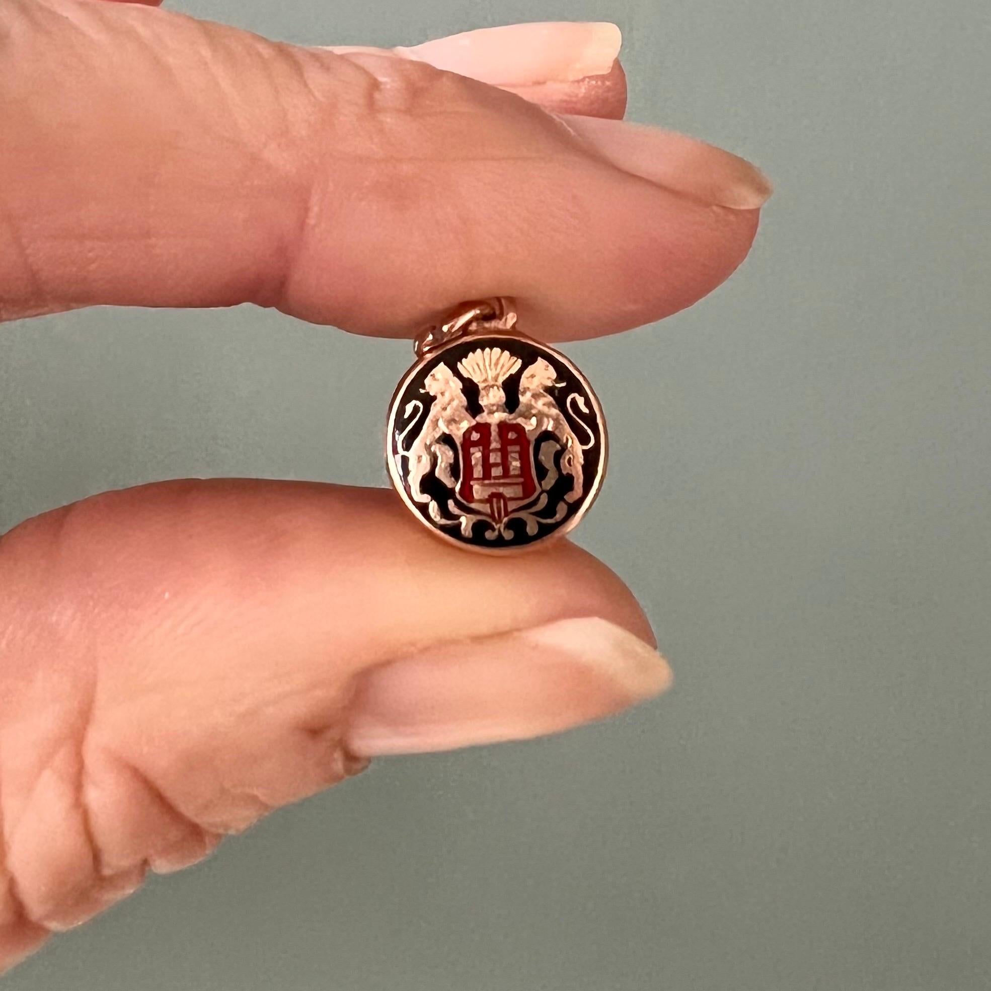 Dies ist ein 14 Karat Gelbgold Vintage kleine runde Wappen Charm Anhänger. Das Schild zeigt zwei Löwen, die ein rotes Emailleschild mit schwarzem Emaillehintergrund halten. Der Charme ist wunderschön in Gold und Emaille gearbeitet.

Charms eignen