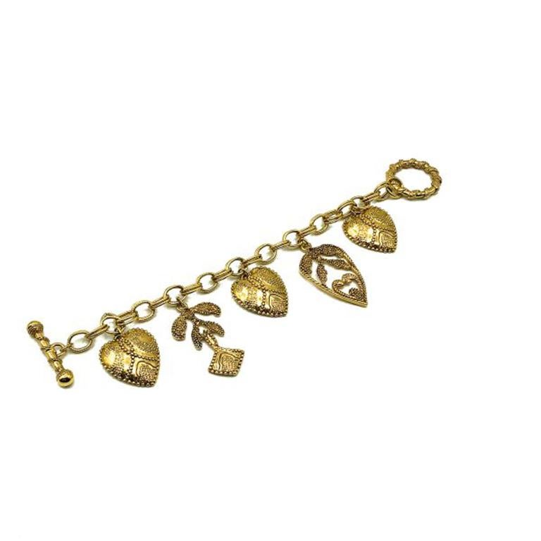 Un très joli bracelet vintage à breloques en forme de cœur. Fabriqué en métal doré. Cette chaîne à maillons ouverts est ornée de cinq charmes fabuleusement embellis. Finition avec une fermeture à œillet. En très bon état, 19,5 cm. Un charmant