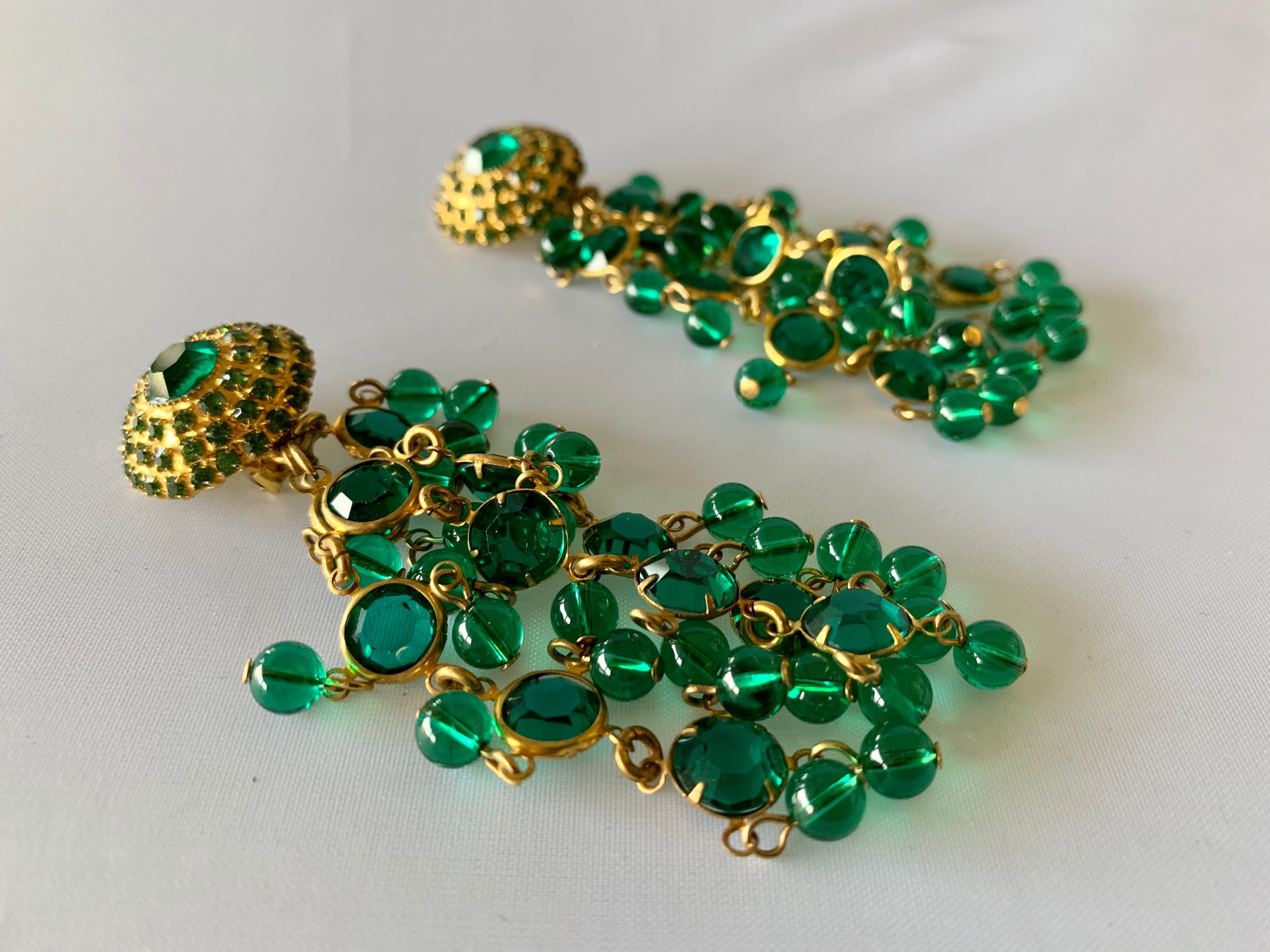 Vintage clip-on statement tassel earrings, comprised out of gilt metal accented by faux emerald rhinestones and beads circa 1970.