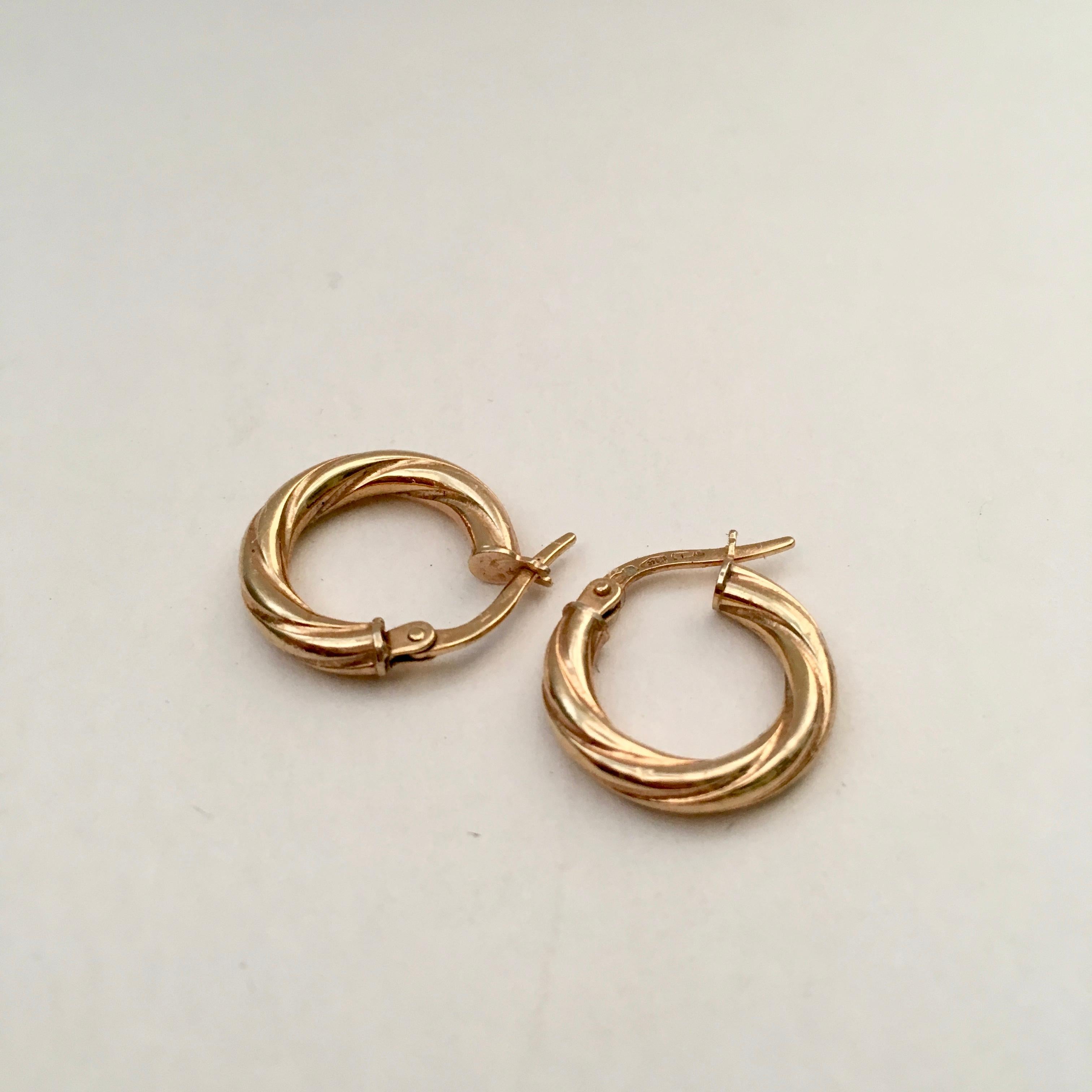 A stylish pair of genuine vintage gold hoops in a twisted design. They are on the smaller size at 1.5cm by 1.6cm with a depth of 0.3cm. They are hollow so lovely and lightweight to wear. Each post is stamped with 375 for 9 carat gold and the posts