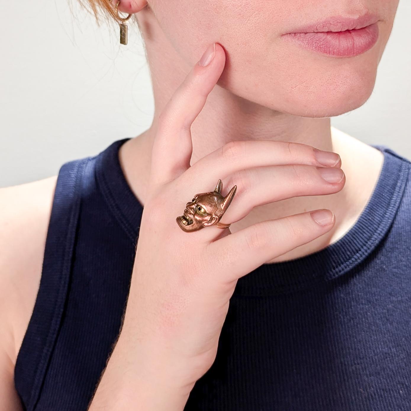 Un fino anillo vintage de oro y shakudo.

Con cabeza de cobre shakduo dorado en una montura de oro de 10 quilates.

Con forma de máscara japonesa hannya (般若). 

La máscara hannya se utiliza tanto en las danzas sintoístas kagura como en las