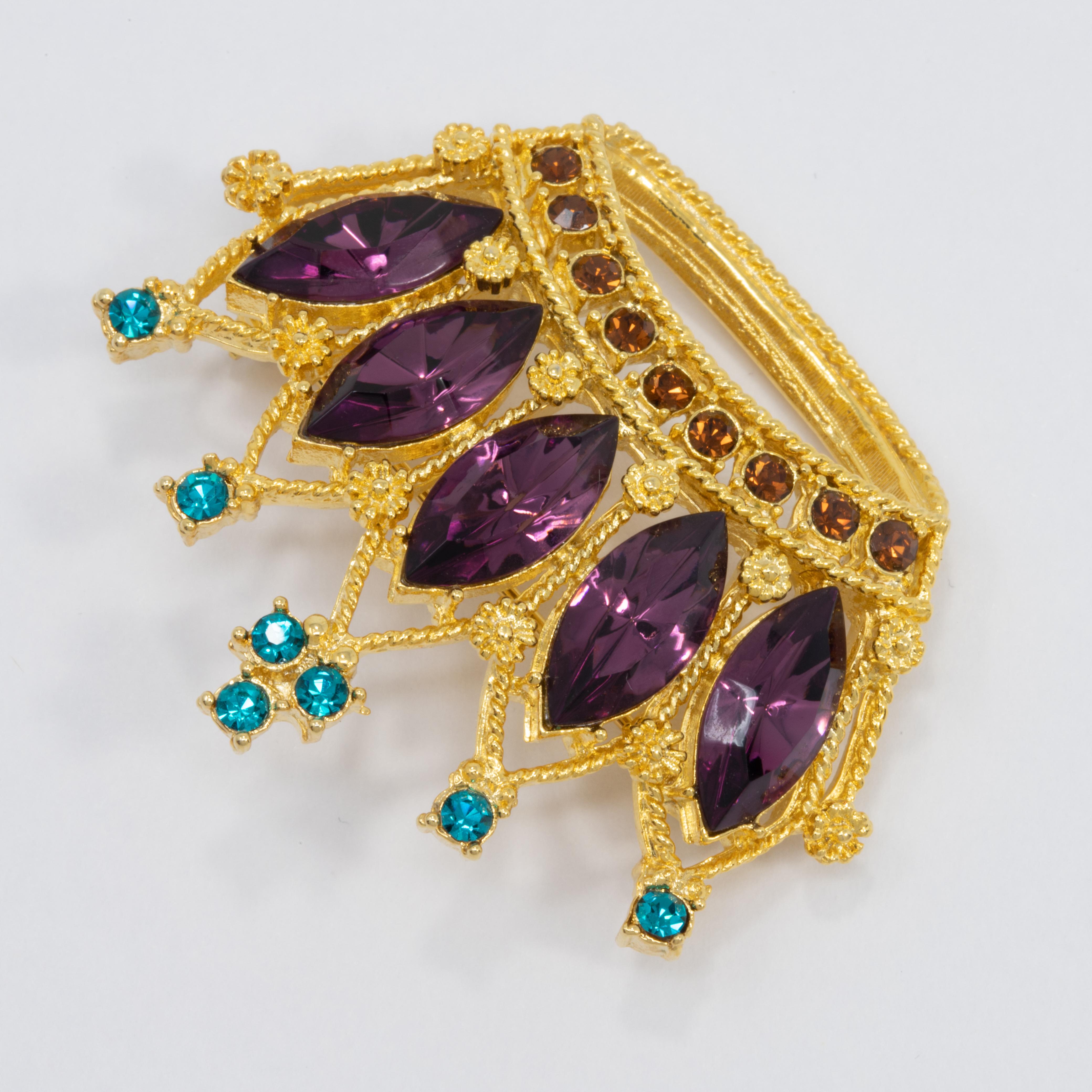 A regal golden crown, decorated with amethyst, emerald, and topaz crystals. 

A vintage pin brooch - never worn, wonderfully preserved!