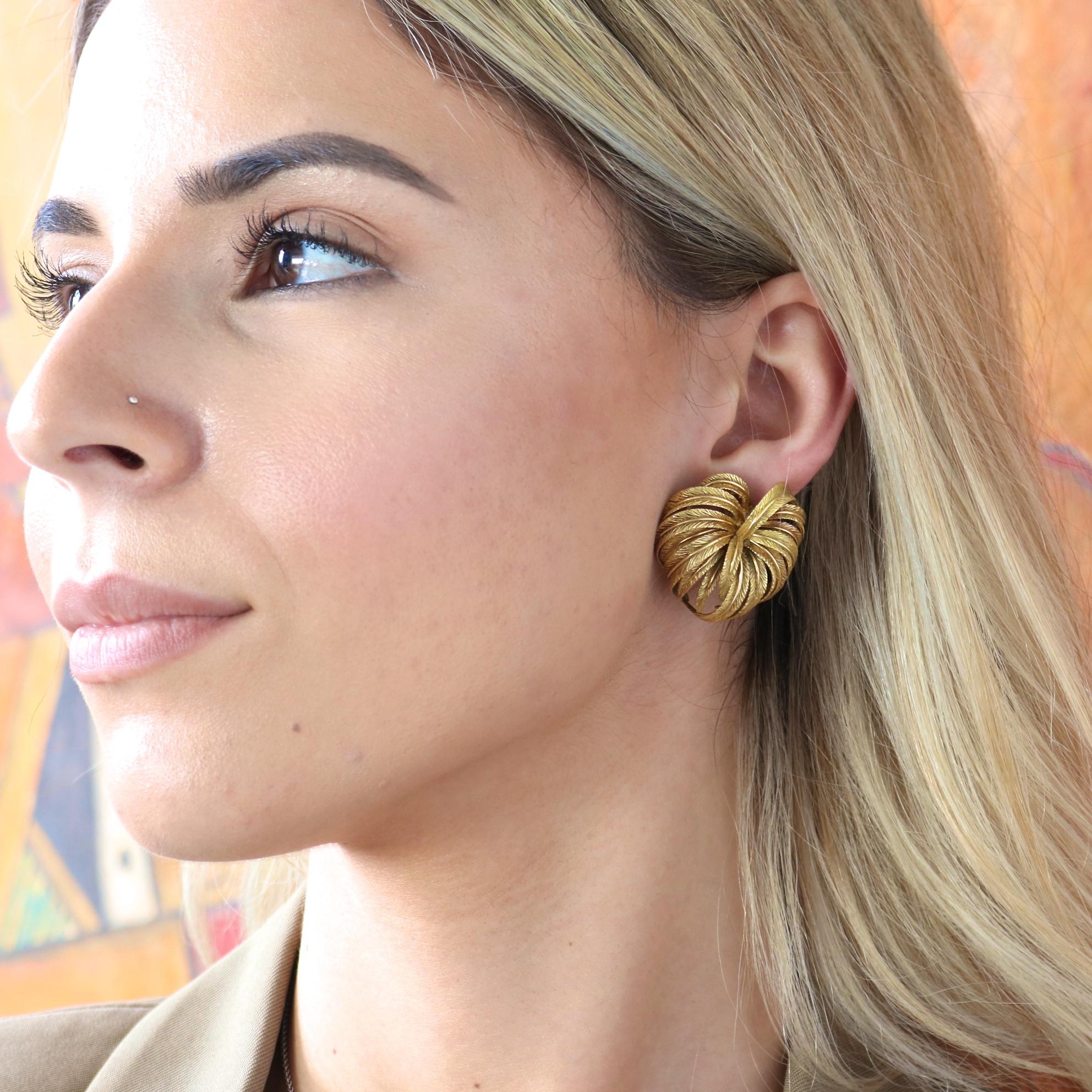 A beautiful leaf motif takes over in these circa 1960's clip on gold earrings. Realistic looking leaves fan out in plumes to create a full and voluminous shape to adorn the ears. The beauty of nature has been well captured with these gorgeous