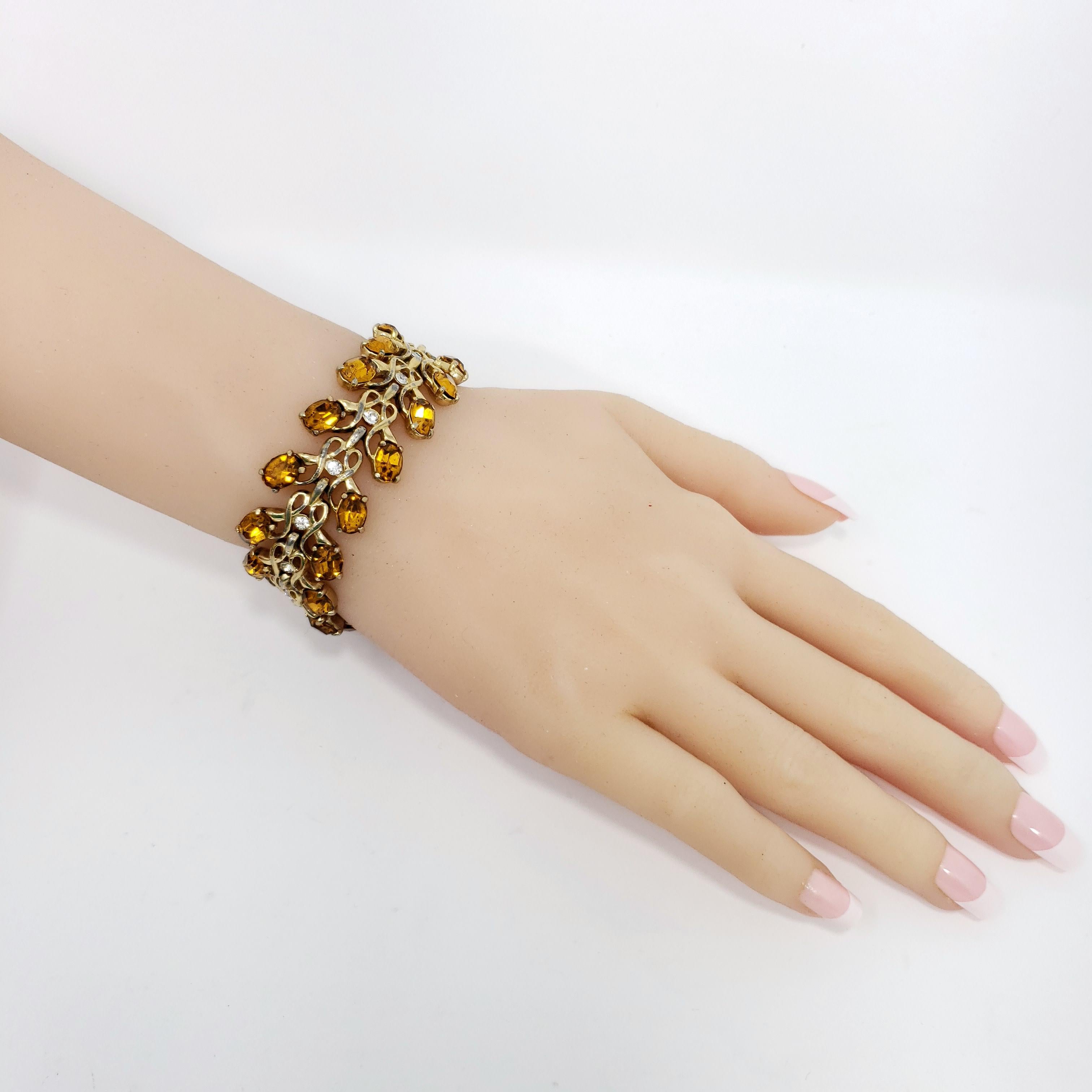 Stilvolles Retro-Armband mit goldenen Gliedern, verziert mit Bernstein und klaren Kristallen.

Vergoldet