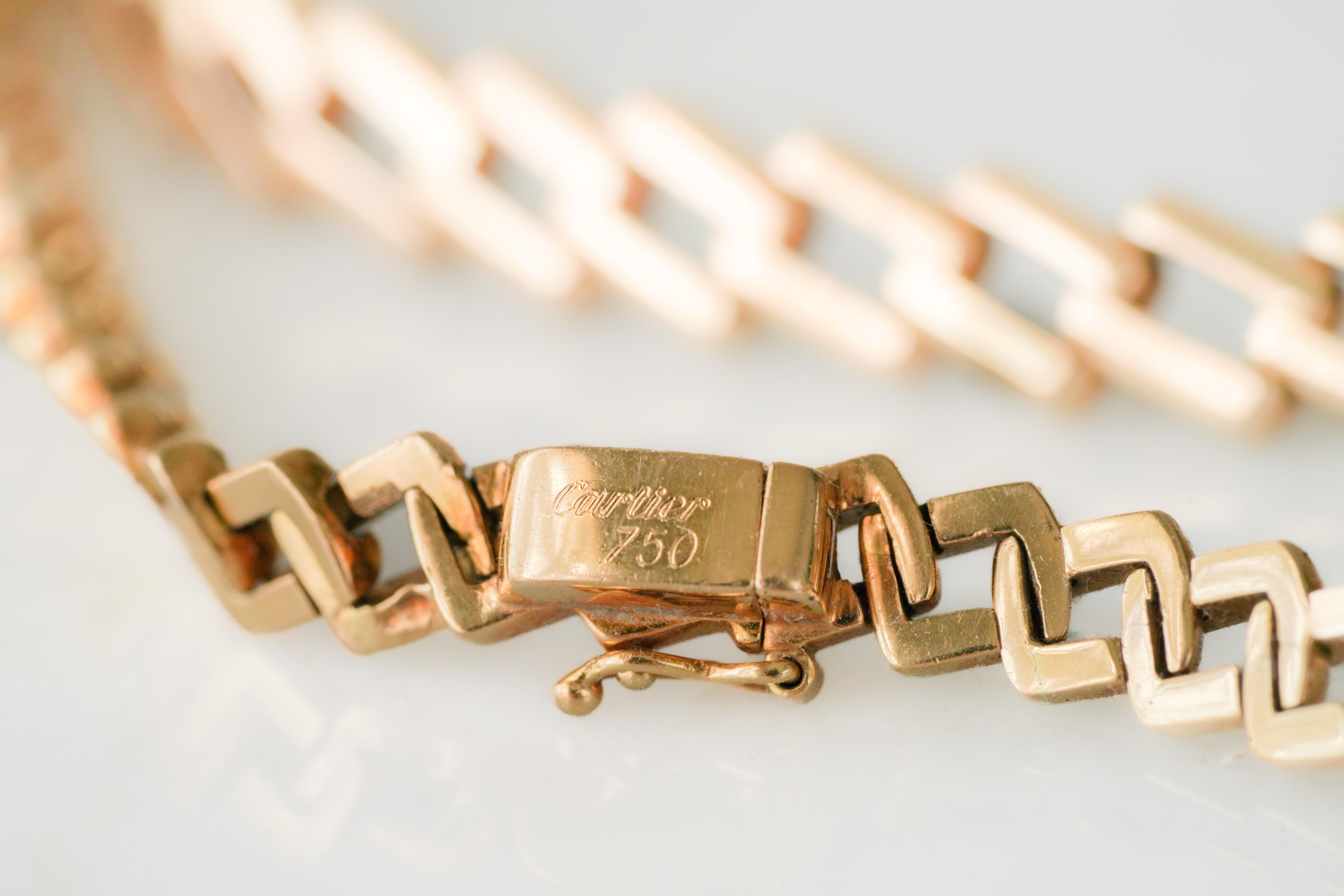 Or jaune 18K  chaîne de Cartier. Formé de maillons rectangulaires obliques qui s'échelonnent doucement vers le centre, signé Cartier.

Condit : très bien.
Date : contemporaine
Poids : 42.2 g
Taille : 37 cm, largeur 0,5 cm
Poinçons : Cartier, or 18K
