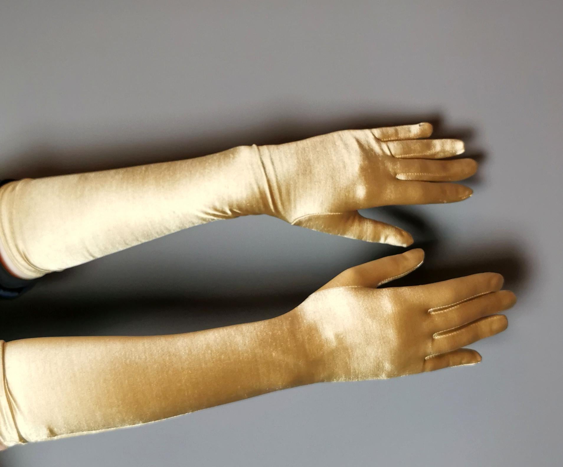 A gorgeous pair of vintage gold coloured long length gloves.

Also referred to as opera gloves this pair are very glam! A rich gold tone nylon with a touch of elastane.

They hug the arm and are sleek and smooth.

They are labelled with the fabric