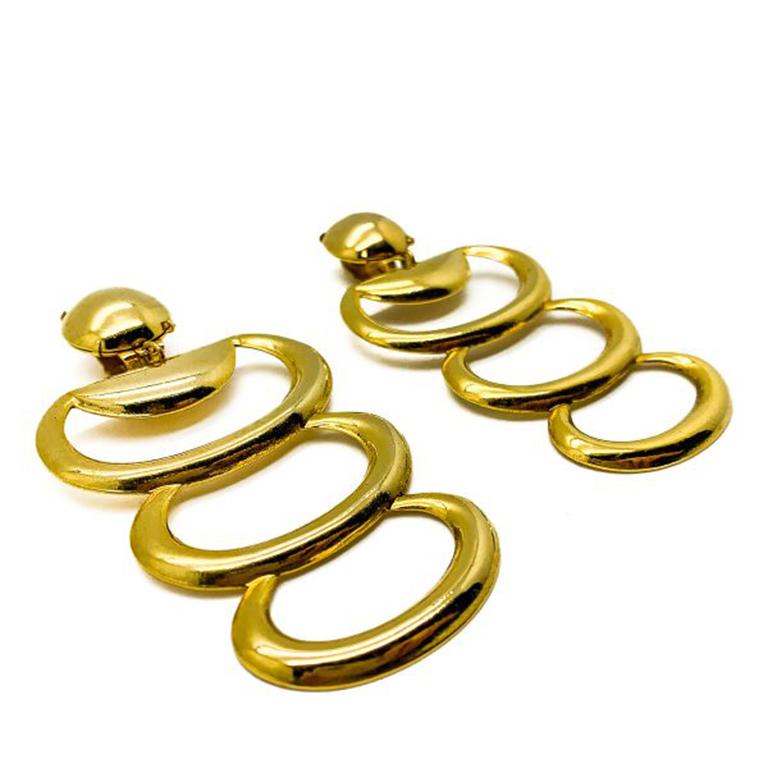 Statement Vintage Hoop Layer Earrings. Featuring gold plated metal designed in a cascading trio of elongated hoops. In very good vintage condition, 8.5cms. A perfect clip on statement earring that will work across your looks. Should you choose to