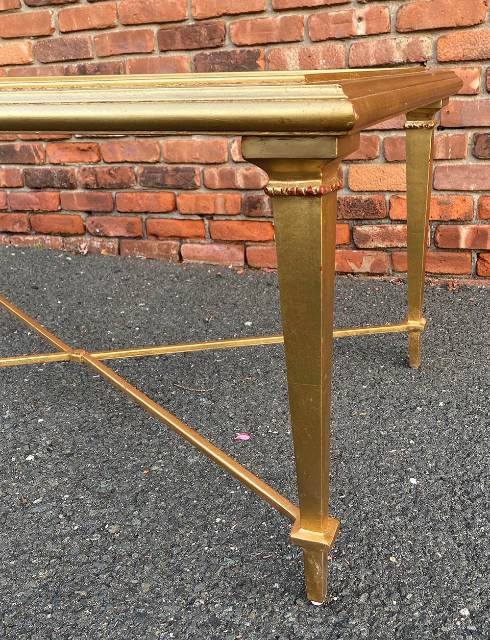 Beautiful gold leaf over metal coffee table with a beveled glass top that sits into the frame. The design can blend into almost any room design with its clean lines and timeless feel. It is very sturdy and is made by welding the metal not screwing