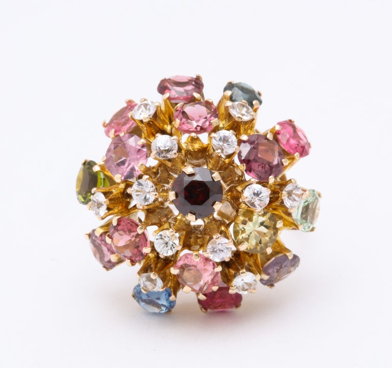 A space age 18Kt Sputnik design ring, taking brilliance from the sun and the moon, is set in four layers of color with a mix of tourmalines, white topaz, peridot and various colors of spinel. The colors shine with radiance and are so cheerful that