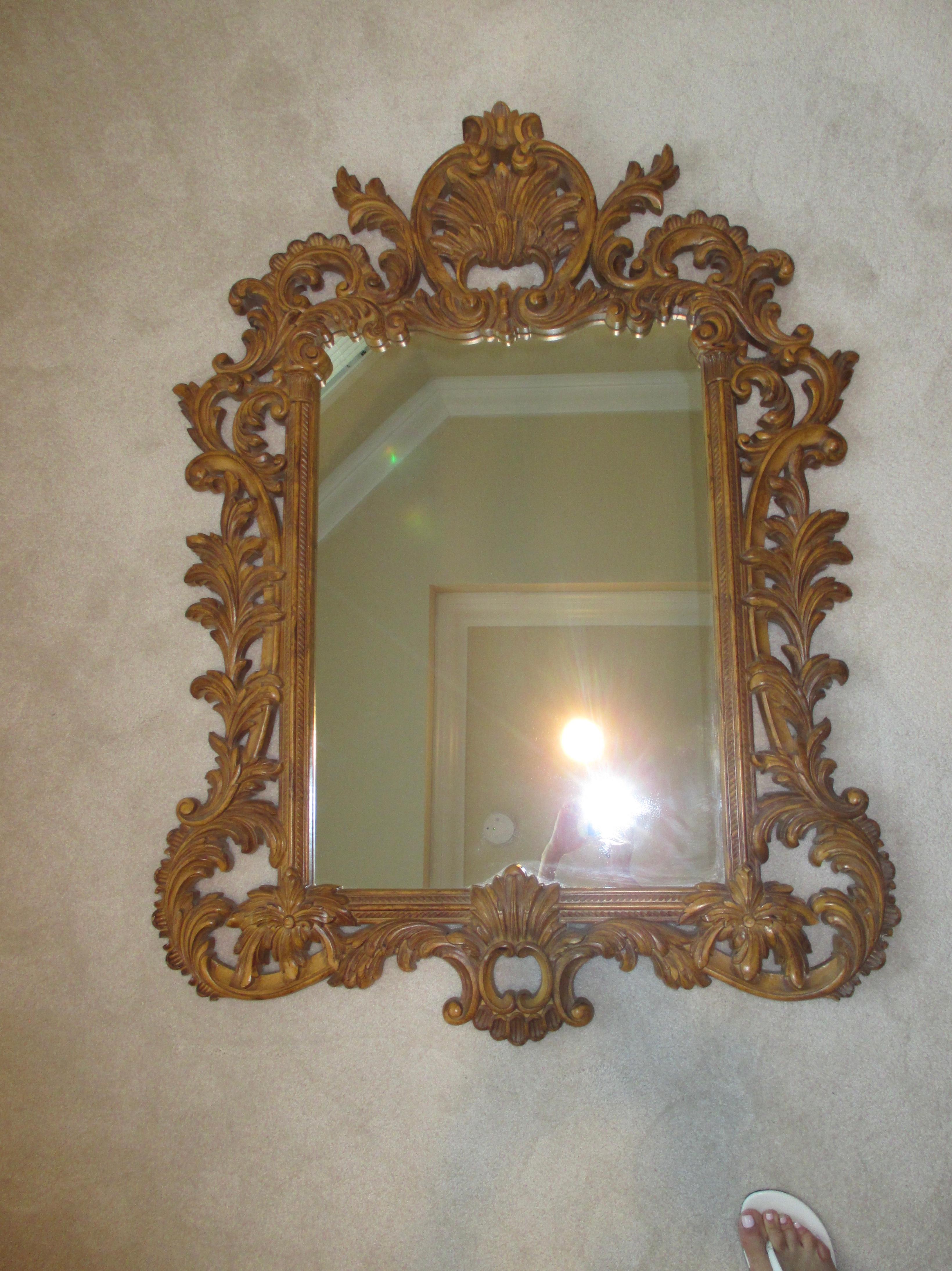 Stunning gold ornate mirror with hanging hardware attached.
 